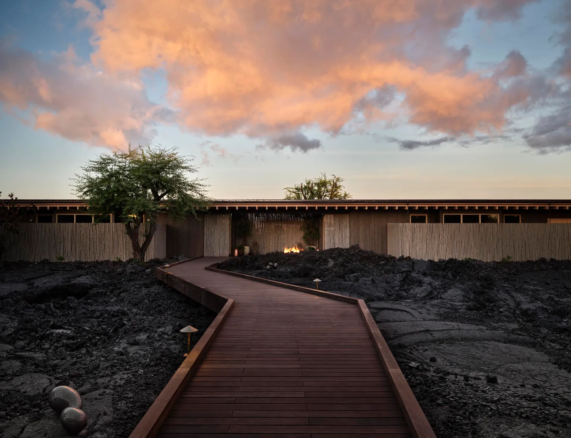 現代住宅式 Spa 空間,木質與竹製沙發置於戲劇性夕陽天色下。