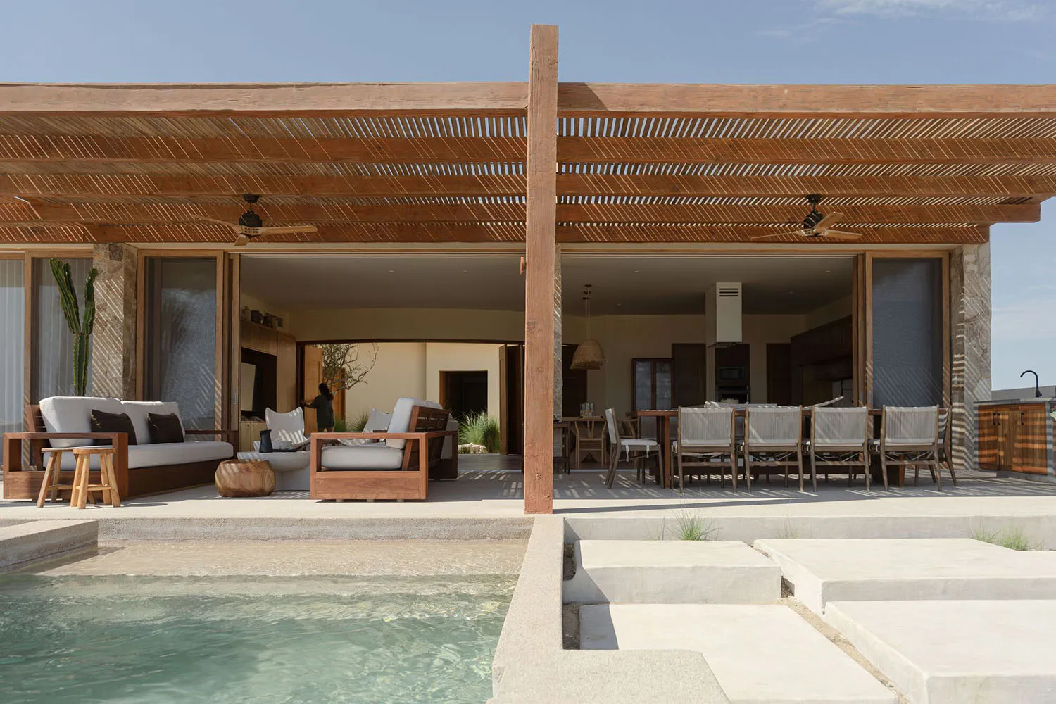 An image of a modern residential wooden porch with a pool in front.