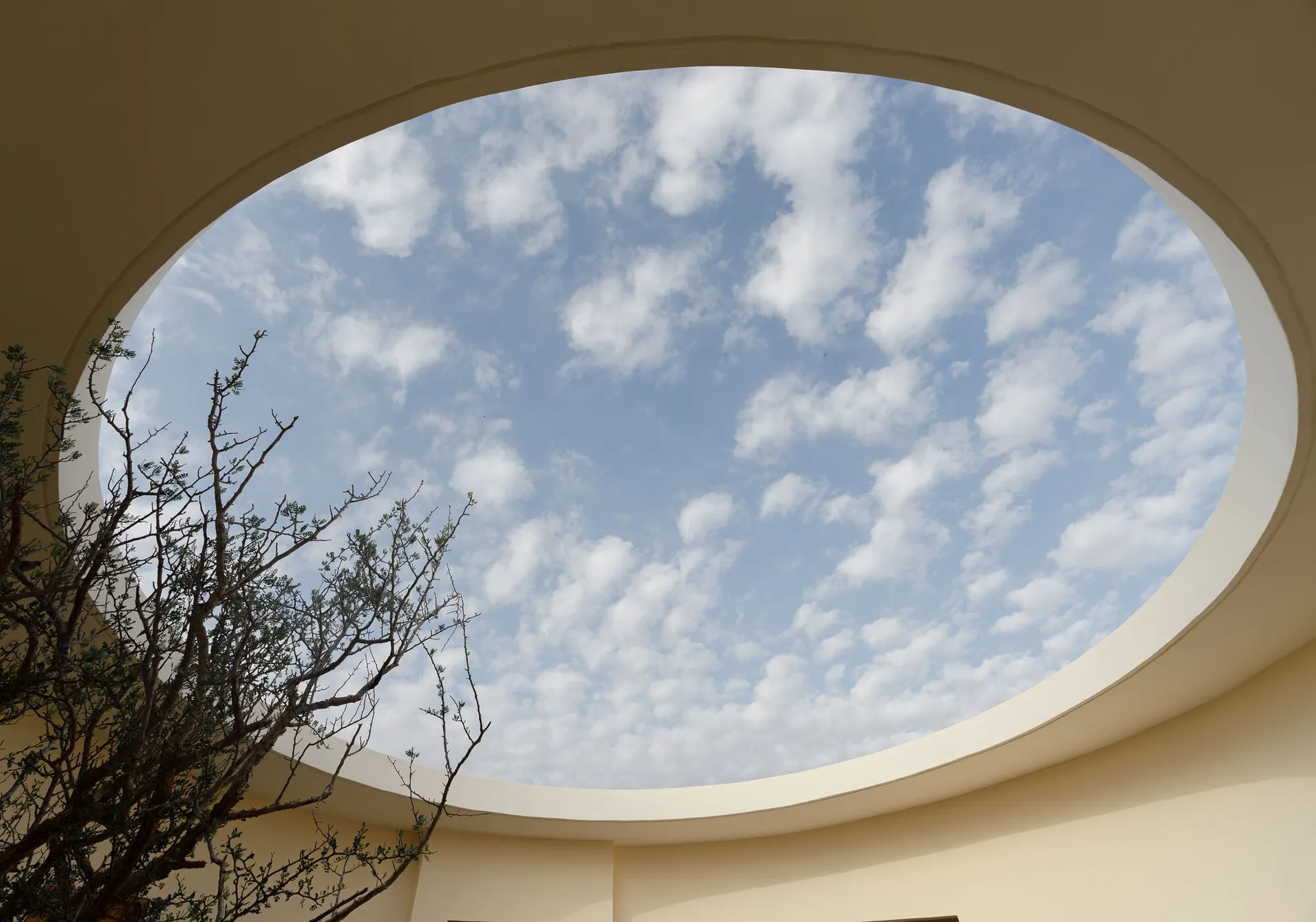A modern architectural design featuring a circular glass skylight.