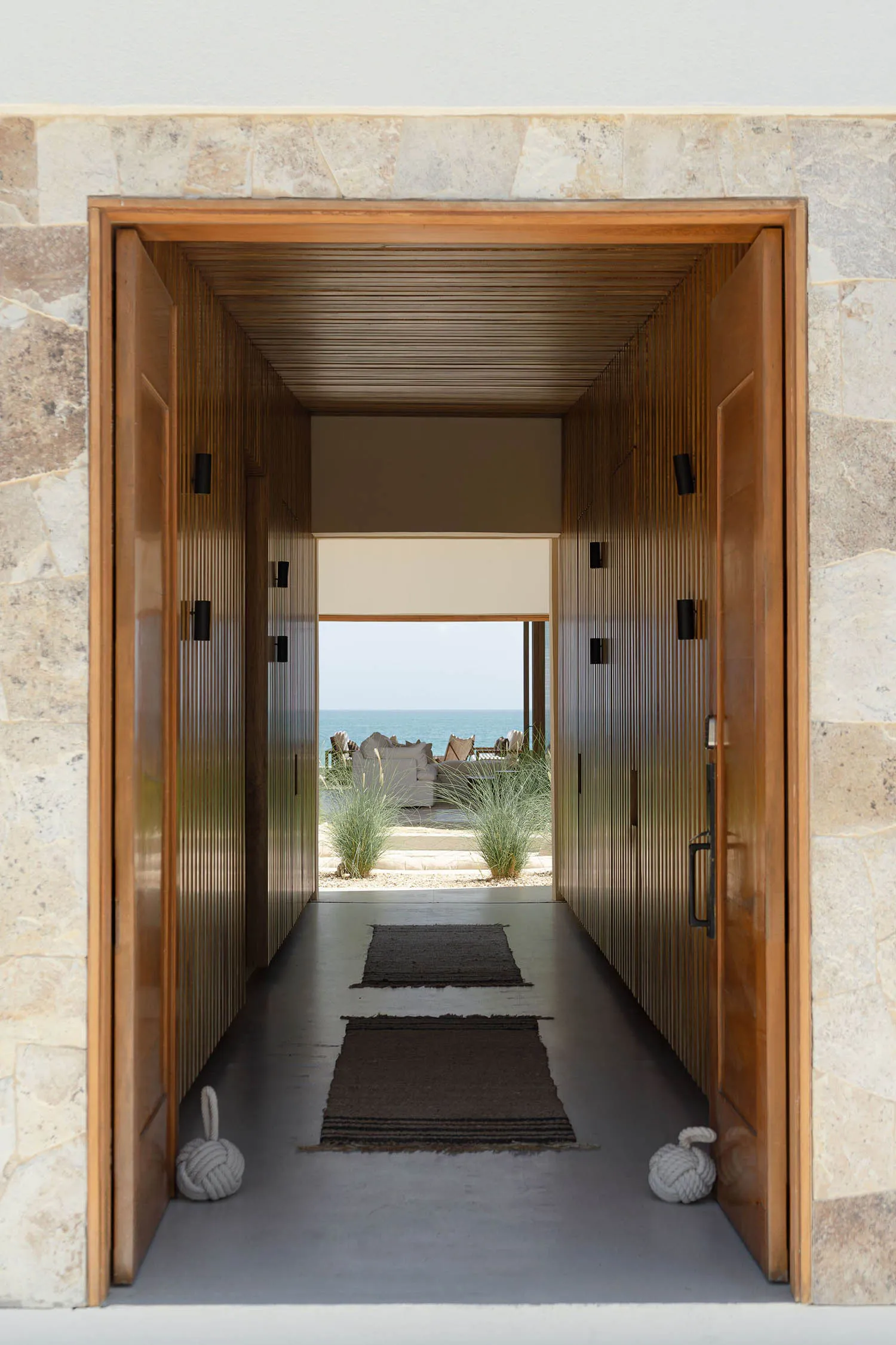 A wooden doorway leading to a garden view.