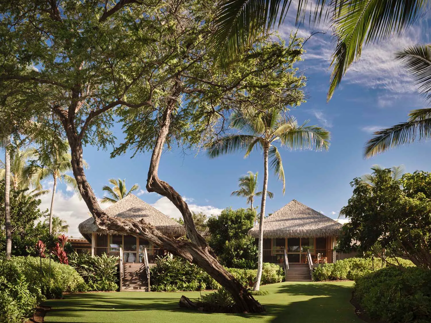 A residential villa with a thatched roof and wooden exterior.