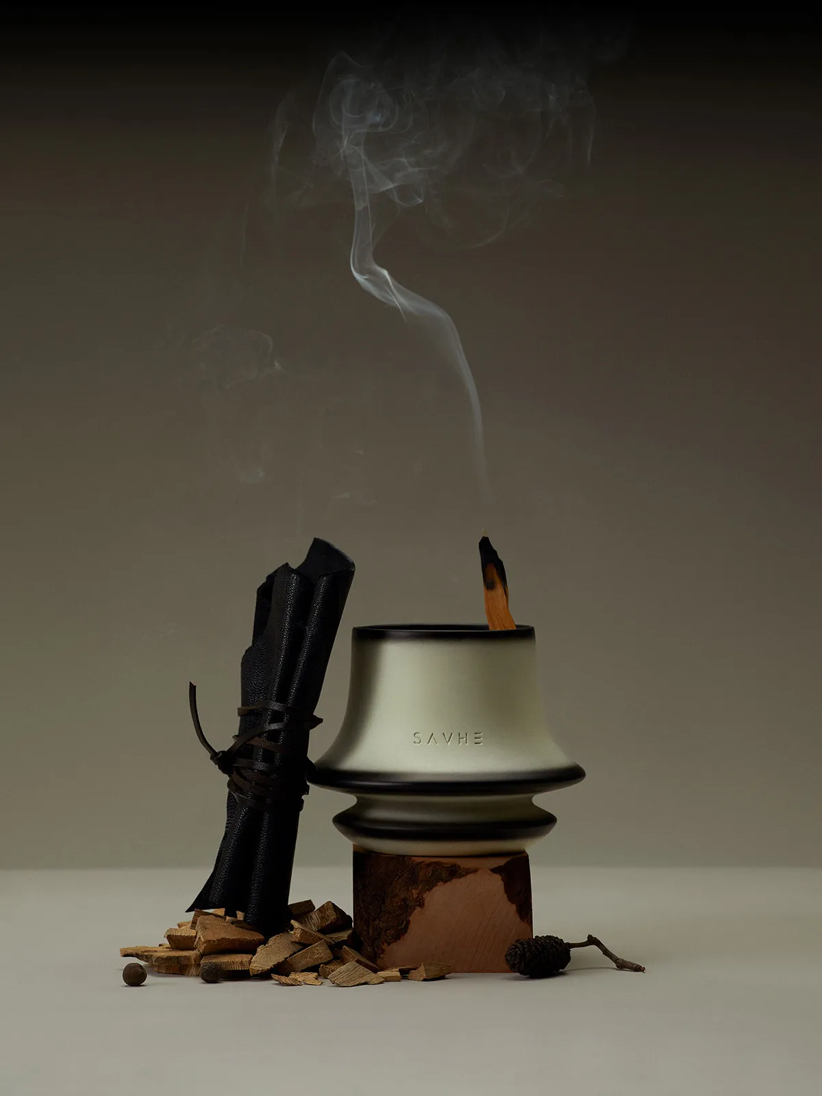 工業風格的金屬香爐，內置燃燒中的香枝，周圍散落木屑與乾燥花材。
