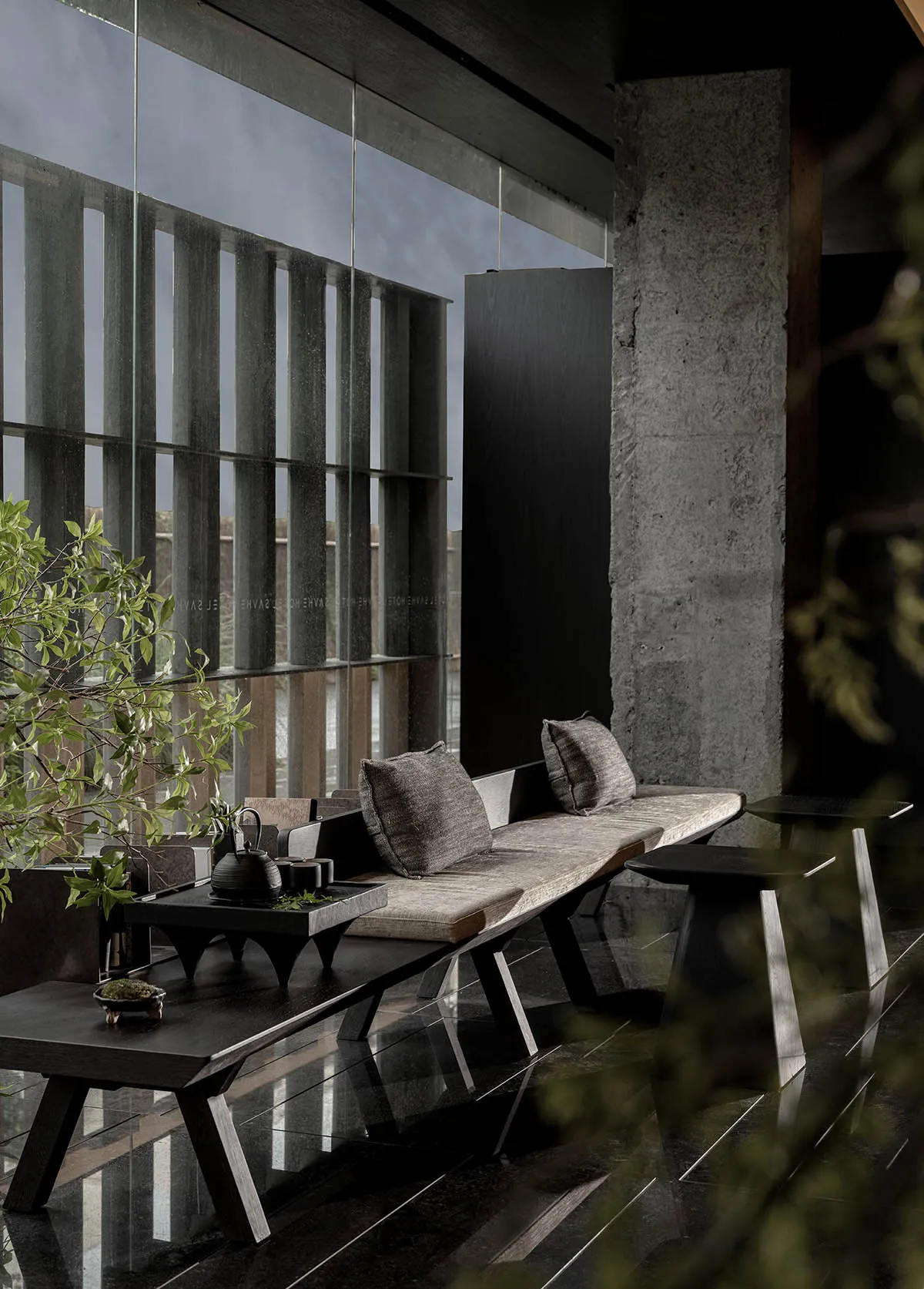 Modern interior design featuring a sleek, minimalist living area with wooden furniture, a concrete wall, and a large window.
