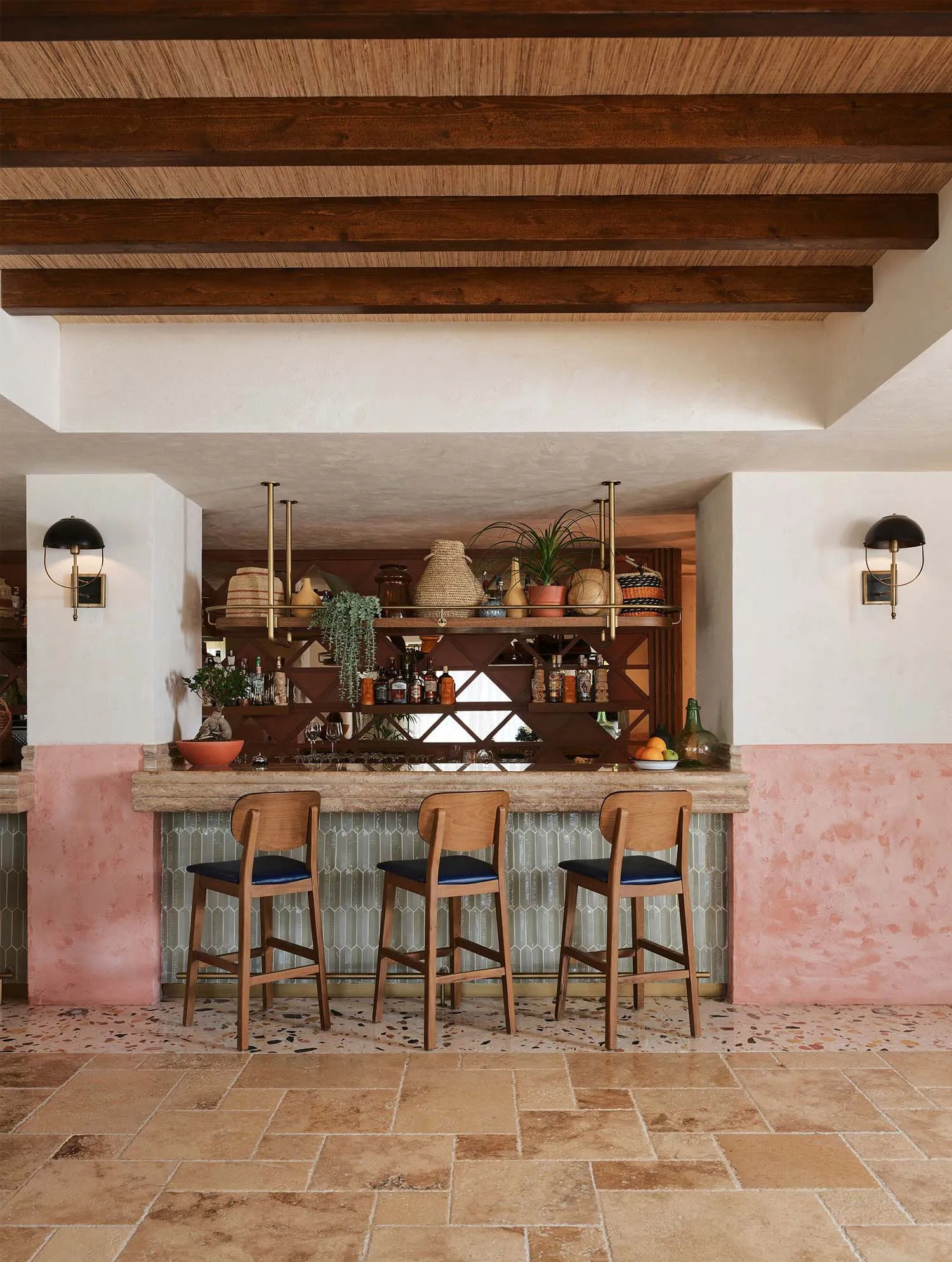 Modern bar interior with terrazzo flooring and wooden stools.