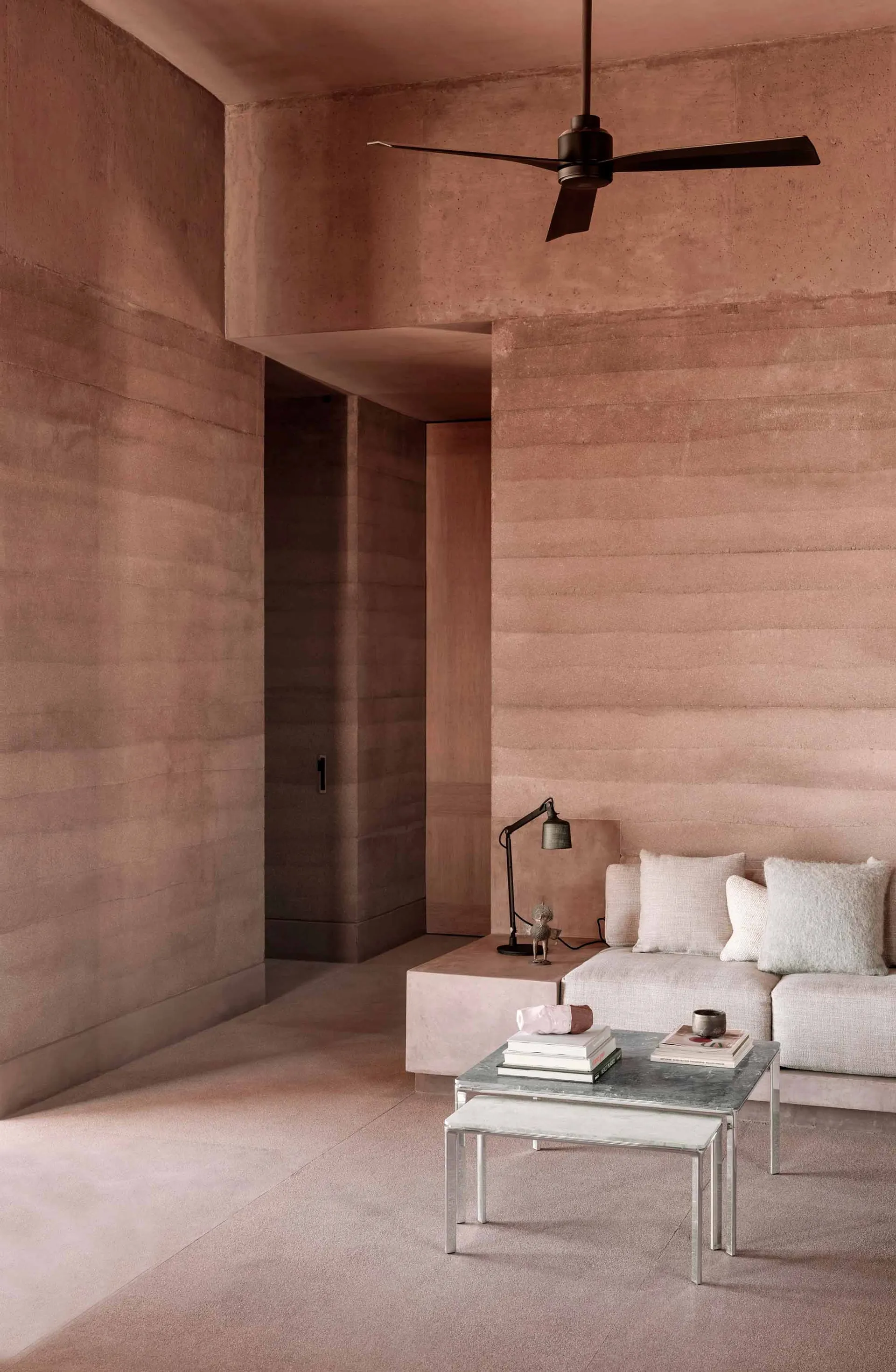 A modern living room with textured concrete walls, a minimalist sofa, and a low coffee table.