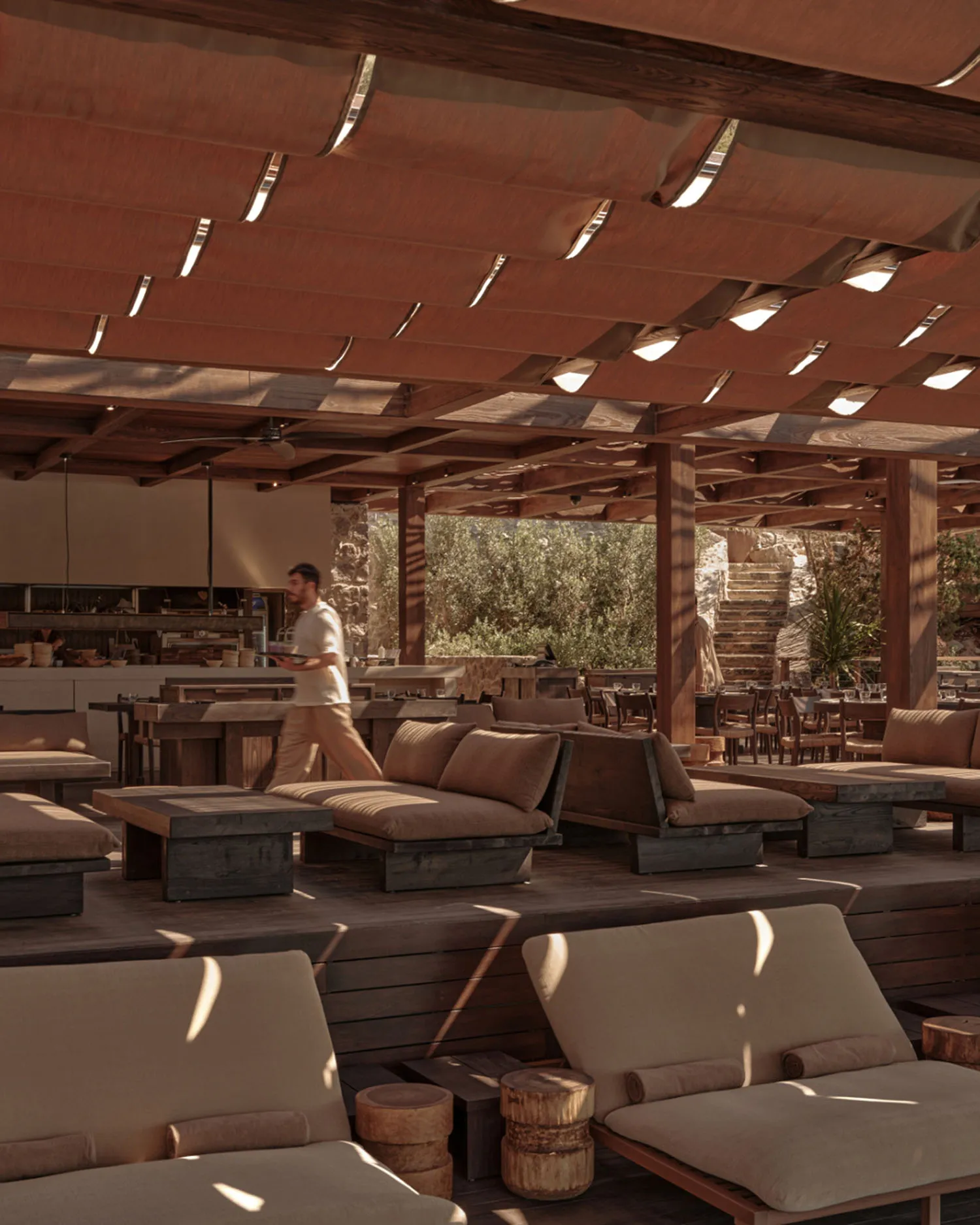Indoor restaurant with rustic décor featuring wooden tables, stone walls, and natural light.