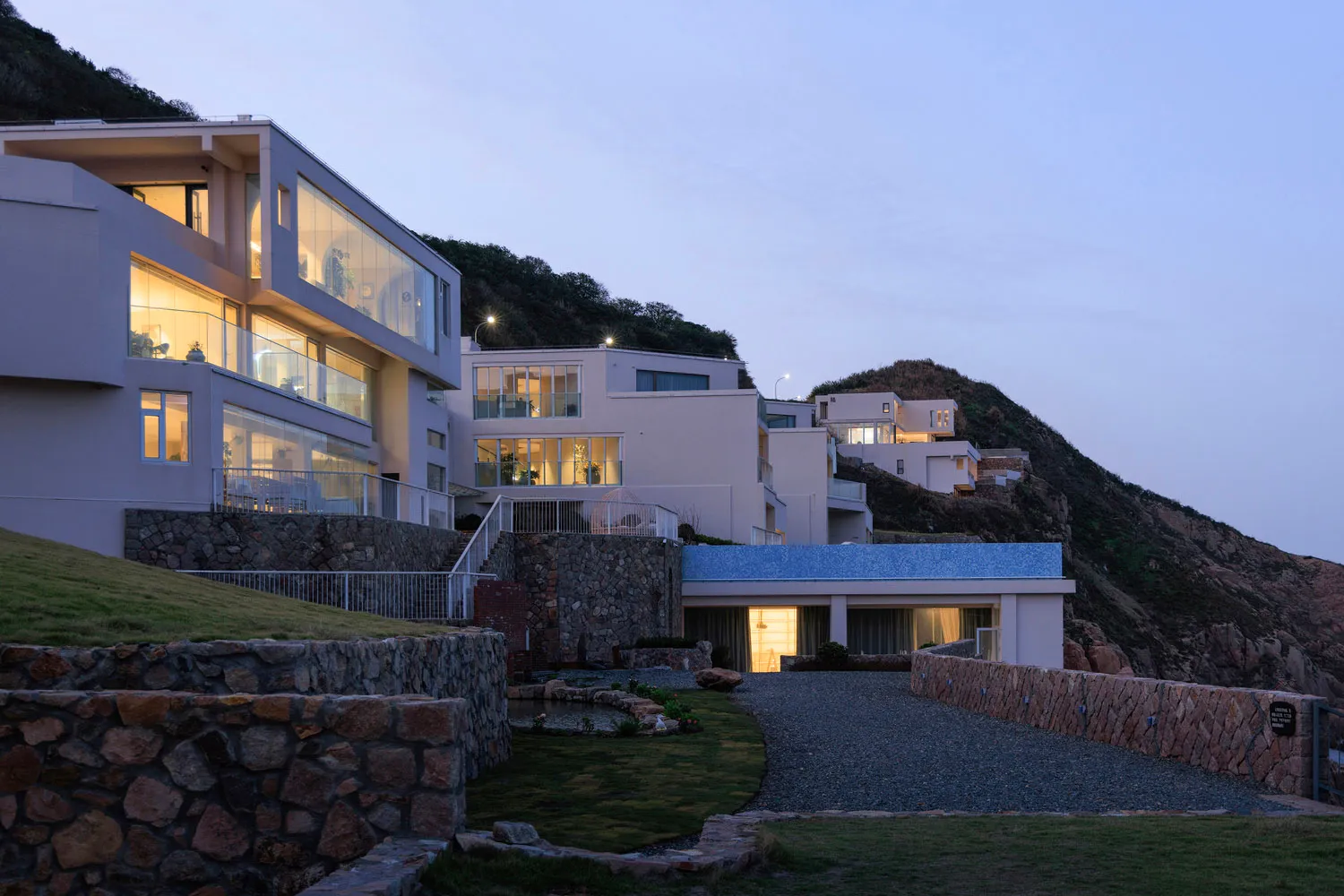 現代住宅建築在黃昏時分,窗戶與外牆照明亮起。