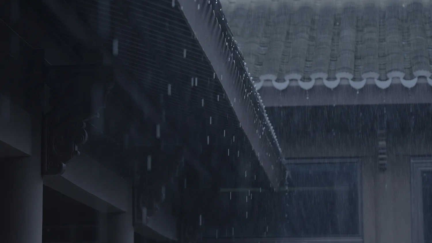 Rice field with rain dripping down from a tiled roof and wooden gutters.