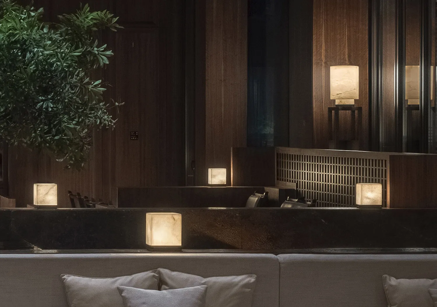 Modern reception area featuring marble decor with lamps and greenery.