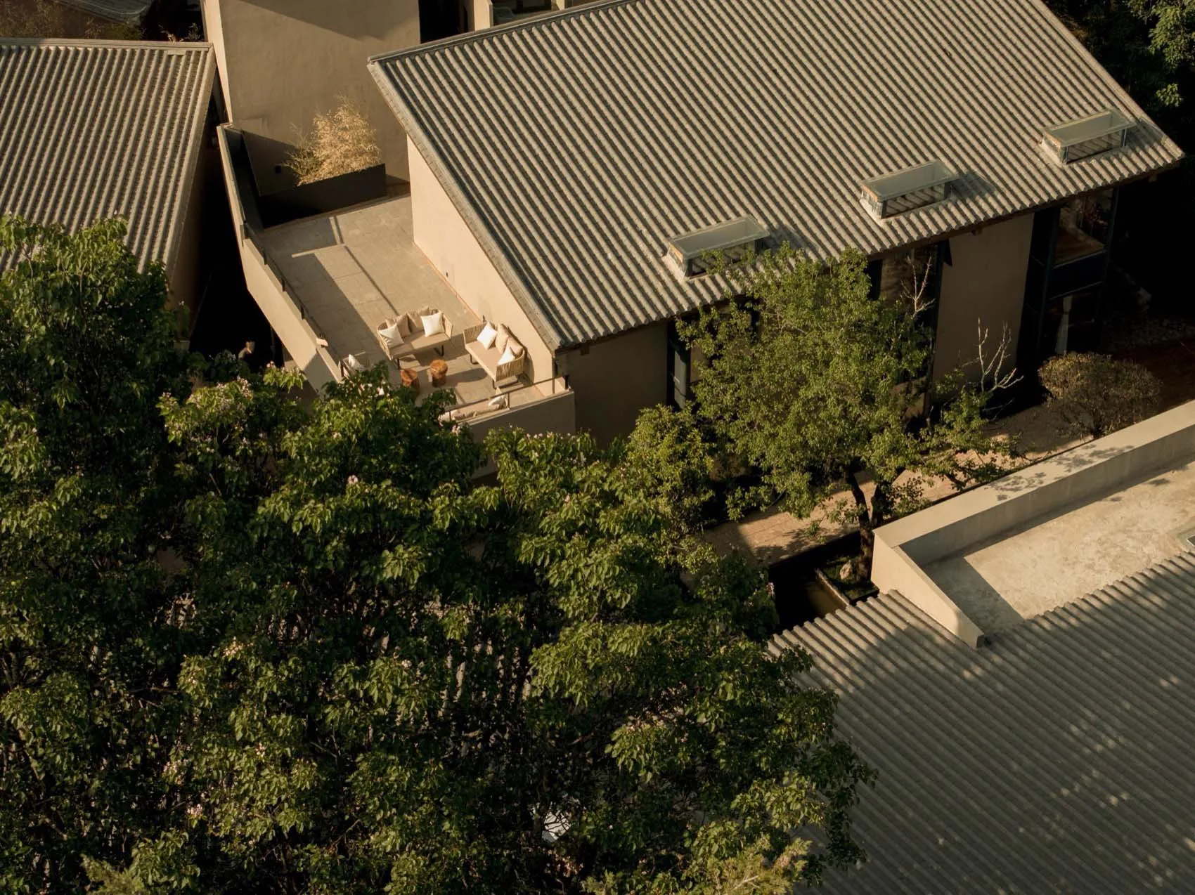 A modern residential exterior featuring concrete walls and a roof with a mix of concrete and wooden materials.
