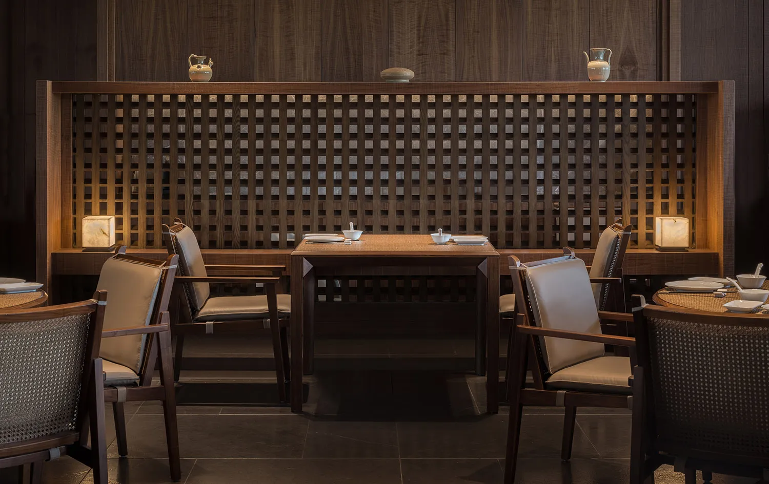 Modern restaurant interior with wooden furniture and lattice partitioning.