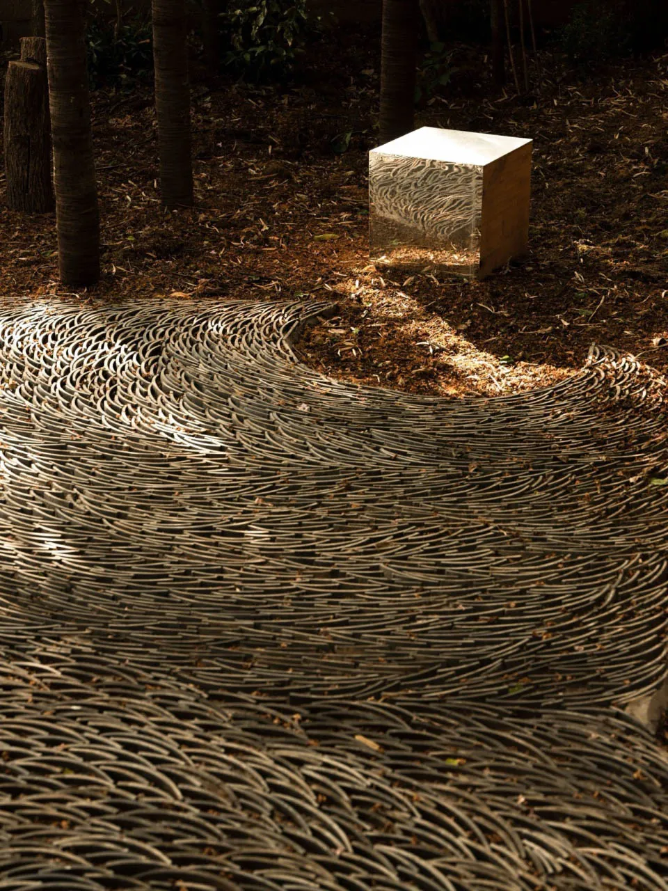 An abstract wooden sculpture with a modern design featuring an intricate wave-like pattern.