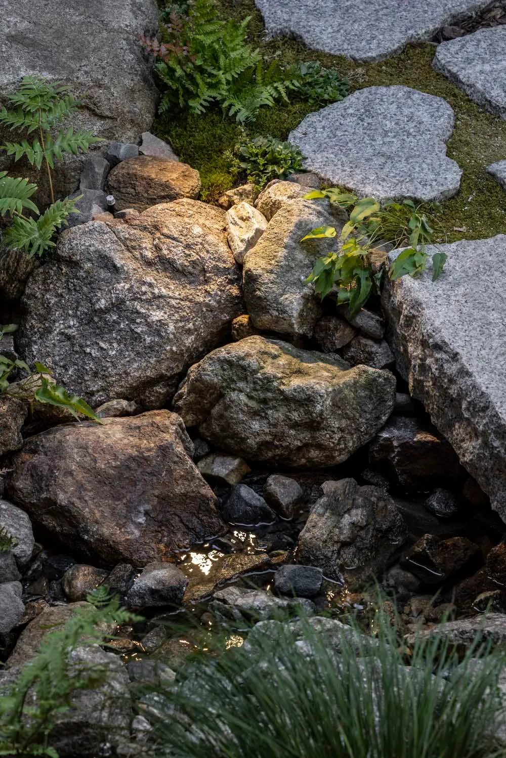 A rocky landscape with large boulders and small pools of water.