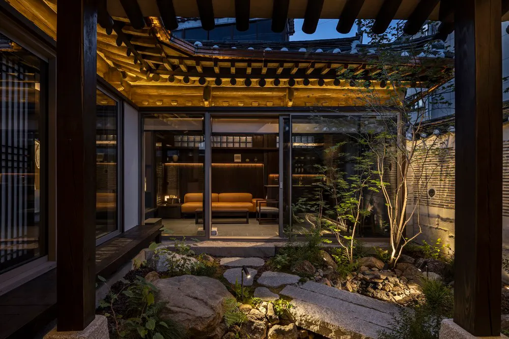 A traditional-style interior living space featuring a rock garden and wooden beams.