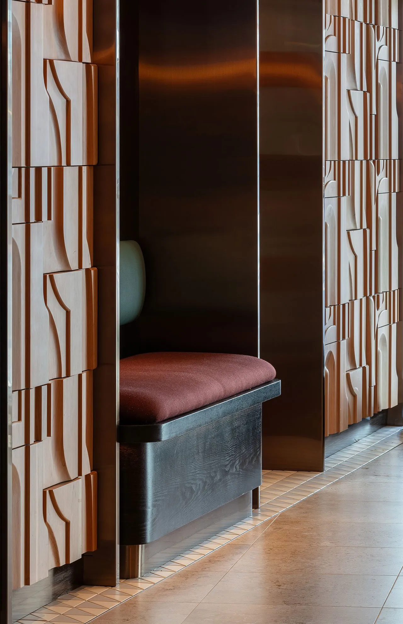 Modern retail shop with wood paneled walls and a bench with a cushion.