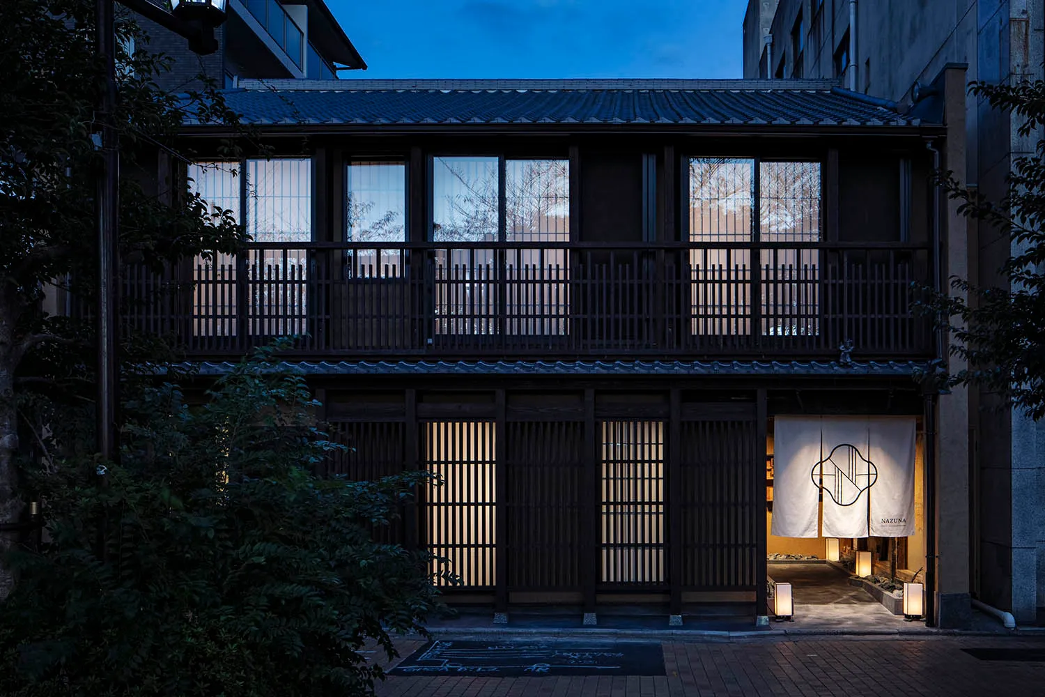 A traditional Japanese restaurant at night with wooden design elements and a welcoming entrance.