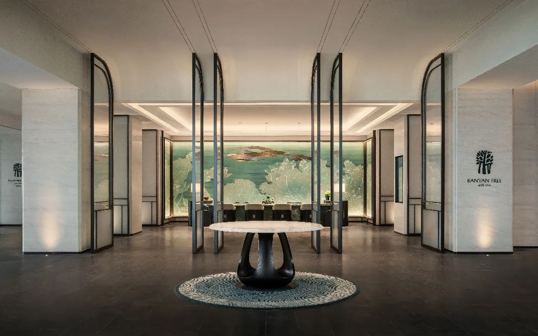 A modern hotel lobby featuring marble, glass, and metal materials
