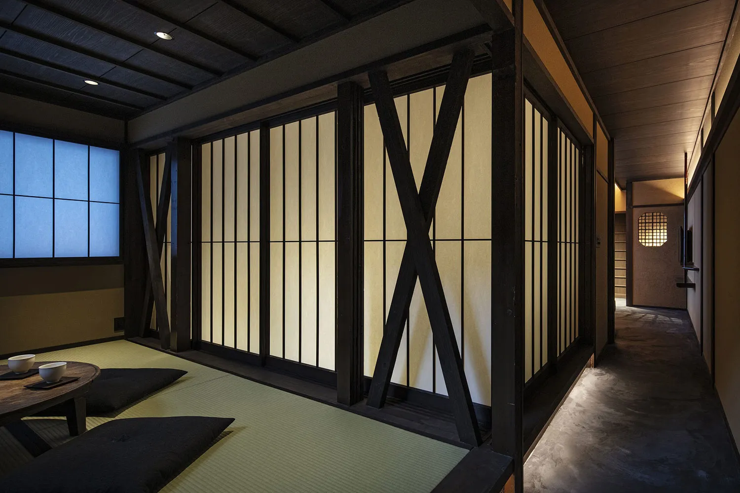 A photograph of a traditional Japanese residential room with wooden walls, sliding doors, and tatami mats.