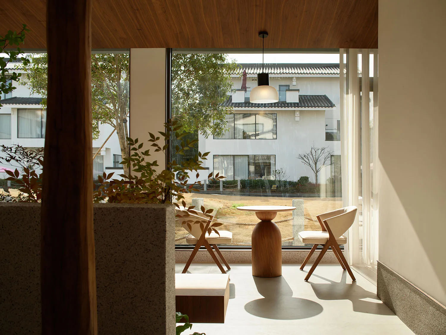 Modern living room with corner seating, minimalist design, and natural light.