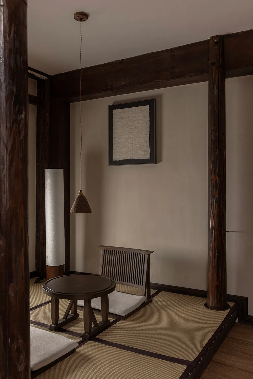 A minimalist living room featuring tatami mats and wooden furniture.