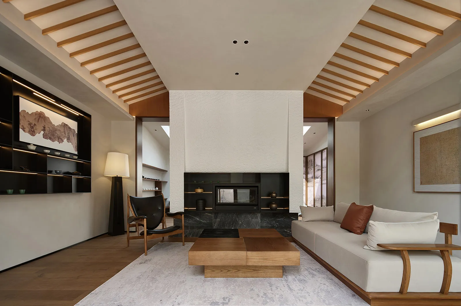 Modern minimalist living room with concrete fireplace and sofa, wooden accents, and light-colored rug.