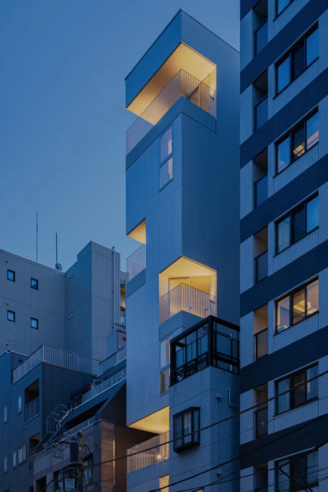 黃昏時分，藍色瓷磚外牆的建築被燈光照亮