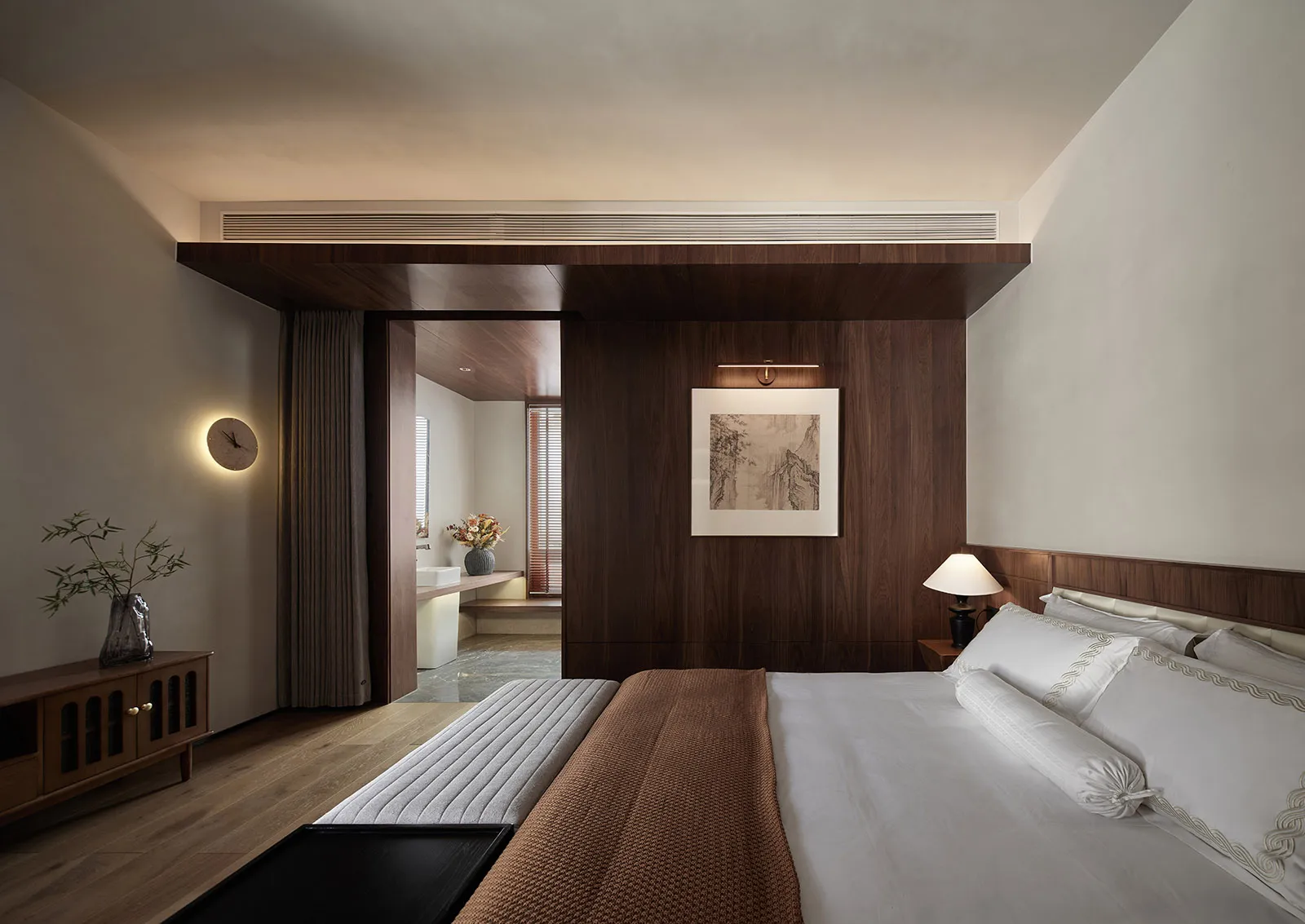 Modern minimalist bedroom with white bedding and wood accents.