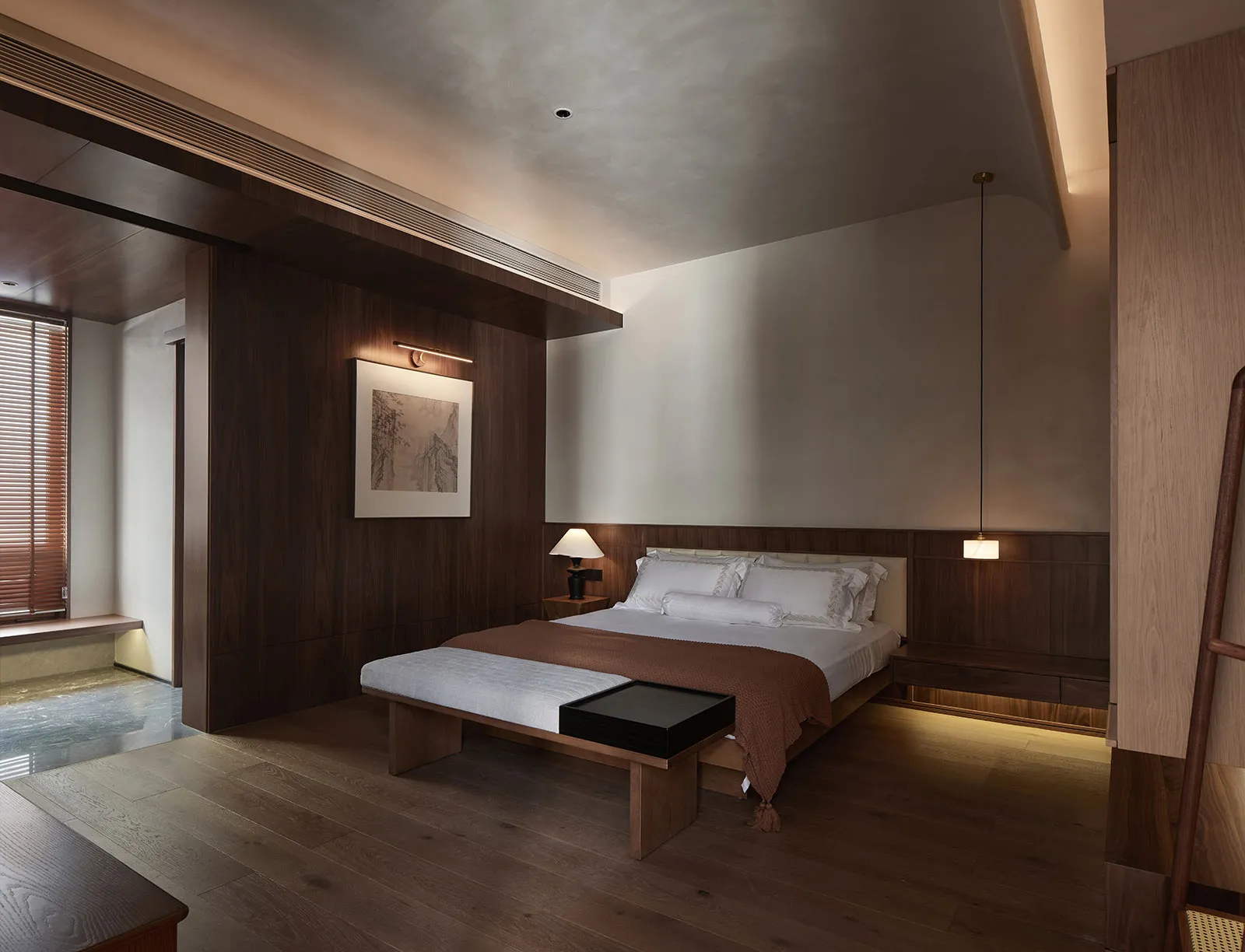 Modern minimalist bedroom with wooden furnishings, white bedding, and a framed art piece on the wall.