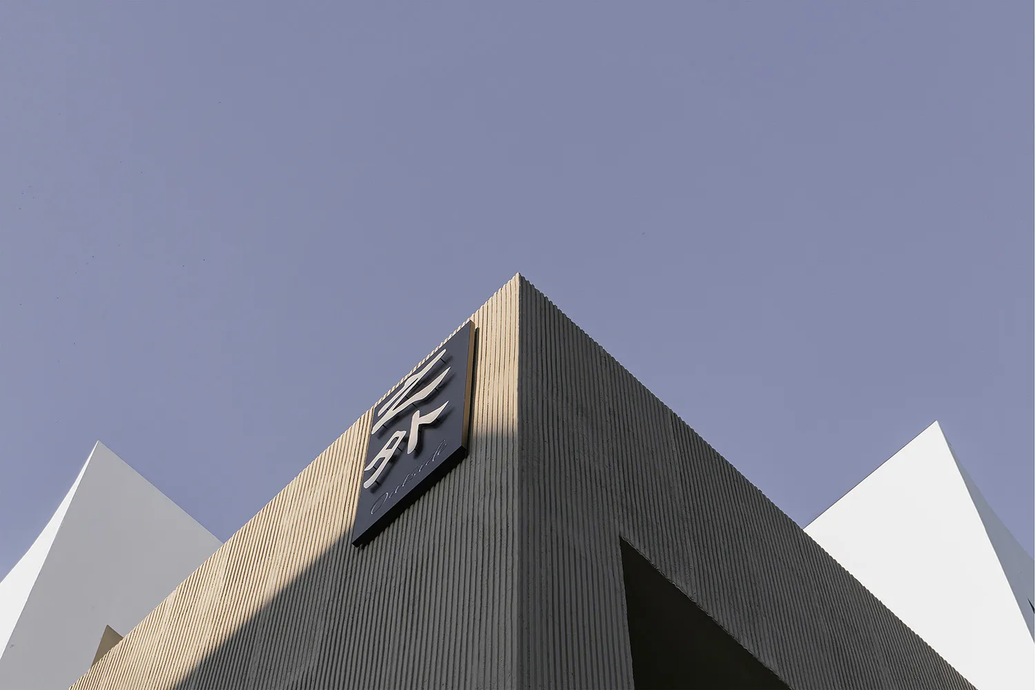由混凝土打造的現代建築外觀，帶有銳利的幾何造型。