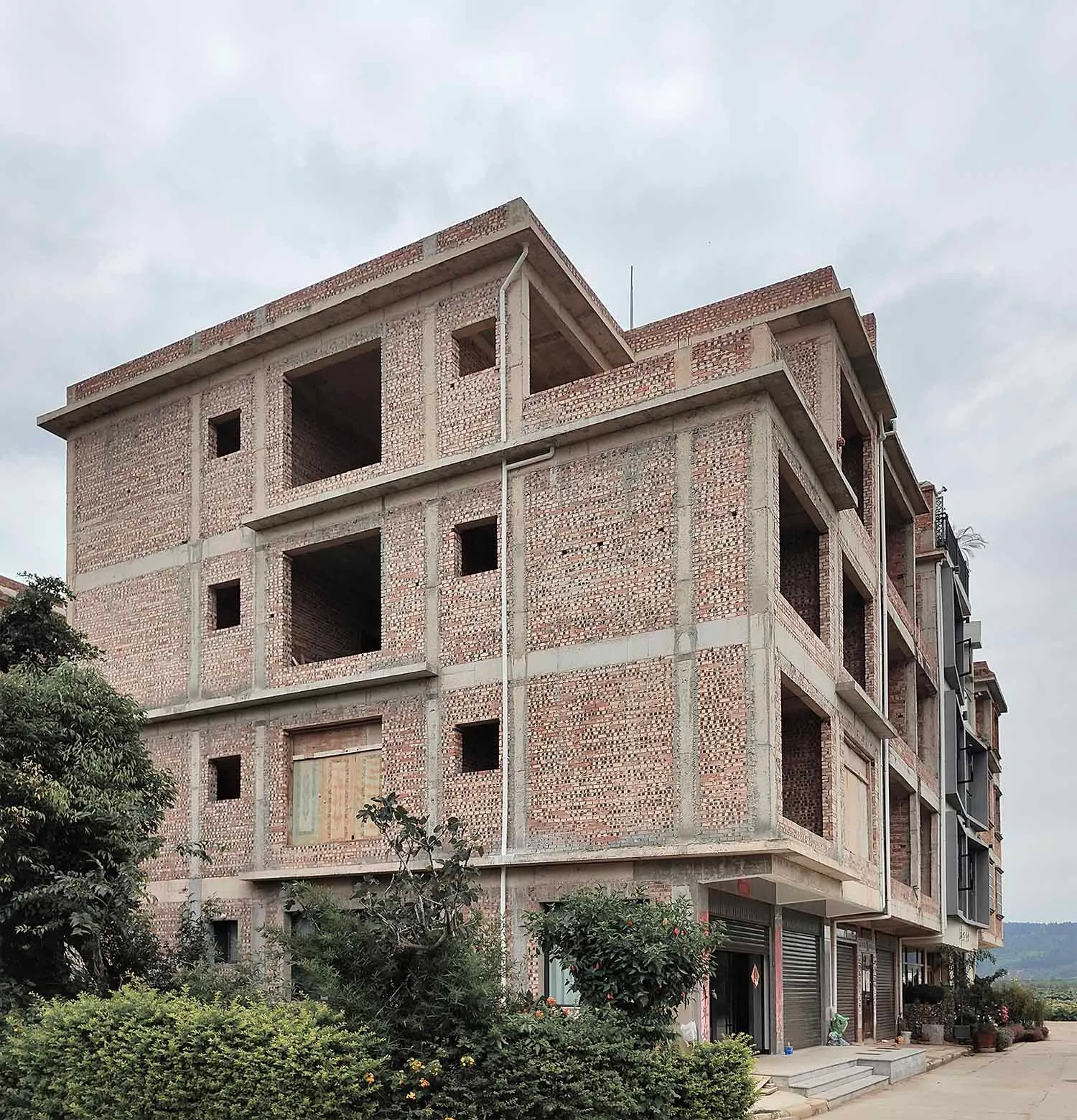 一棟施工中的磚造建築,地板尚未完工且窗戶敞開。