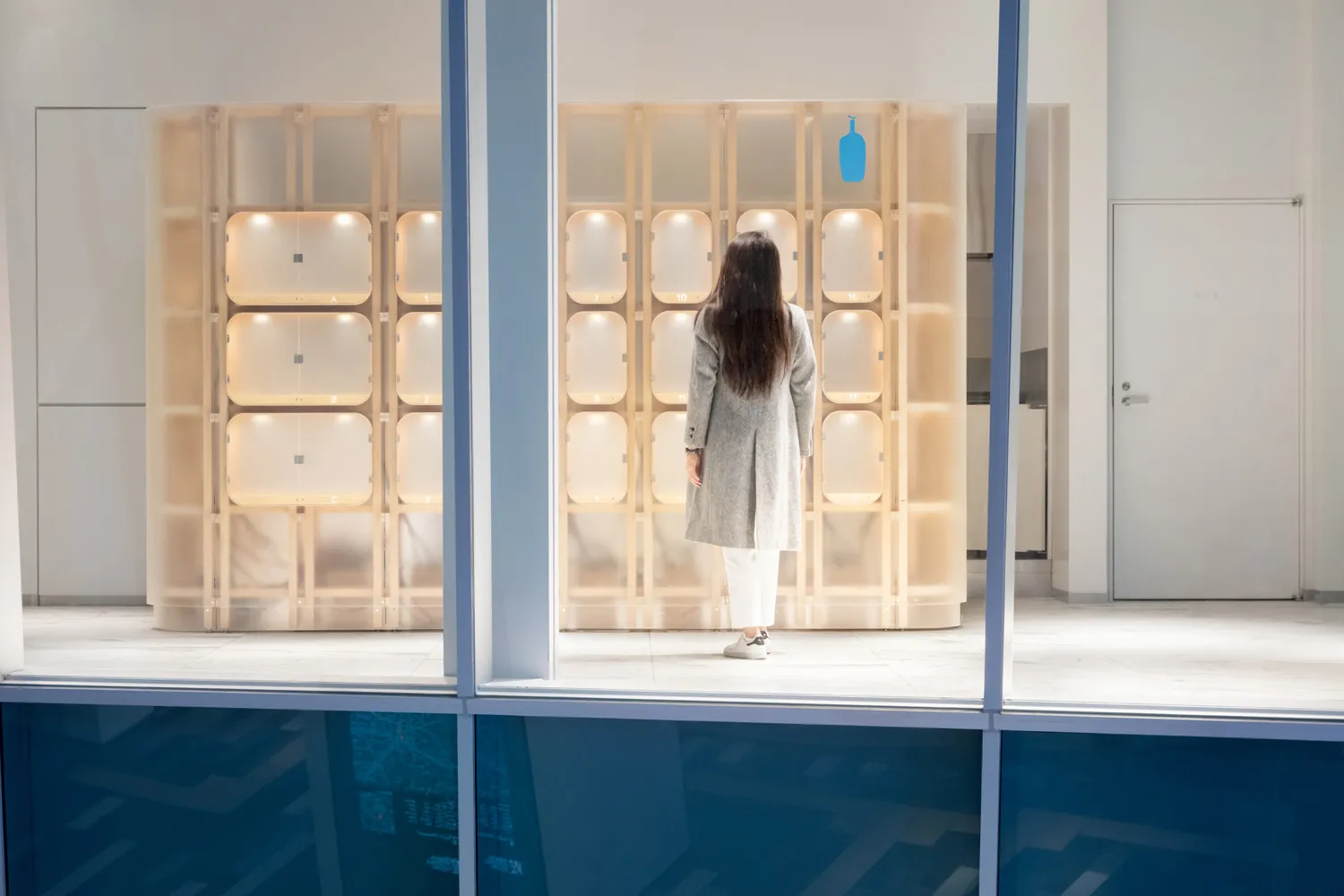 A minimalist installation featuring glass cubes with illuminated lighting.