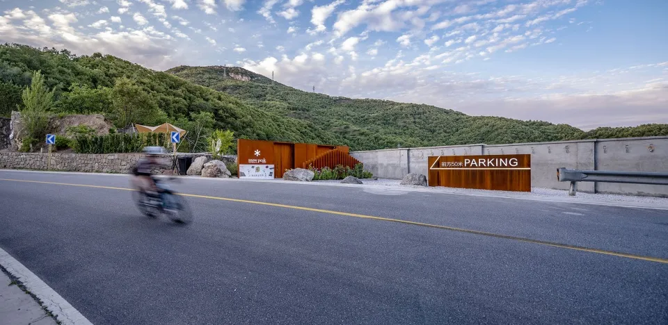 Mountain range with a road featuring concrete barriers and asphalt surface.