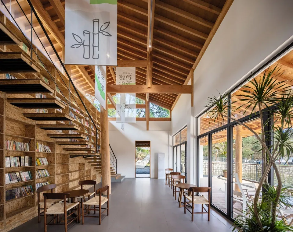Modern library interior featuring wooden shelves and tables with a mix of reading materials.
