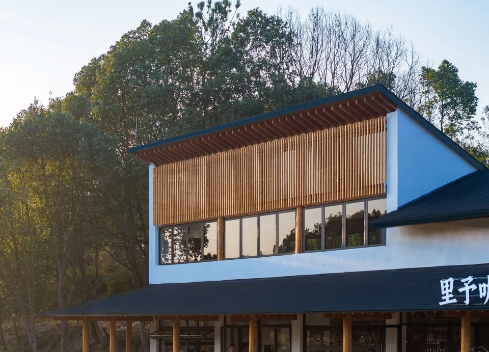 A modern residential exterior with wood cladding and large windows.