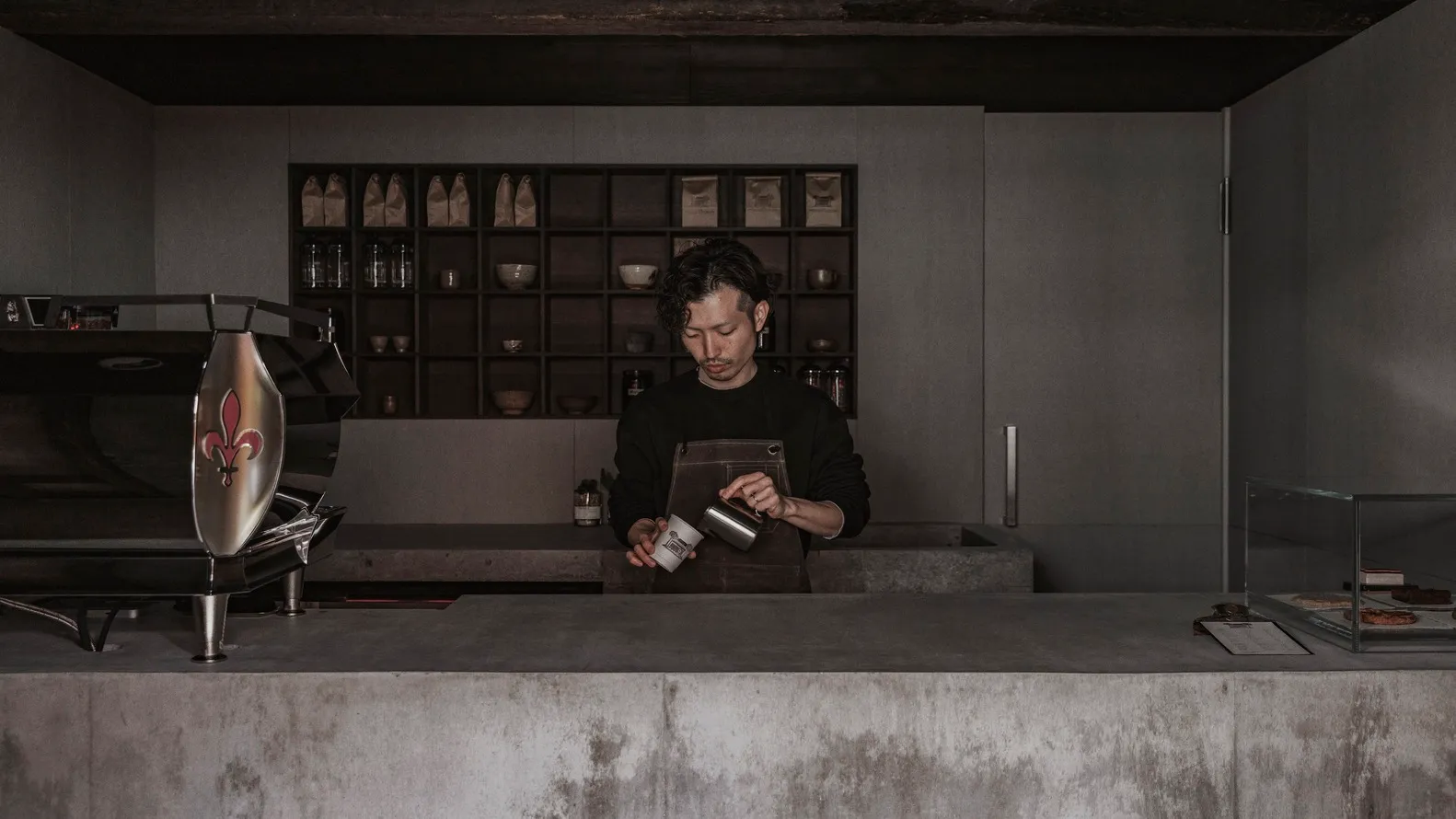 A coffee shop counter made of concrete and wood