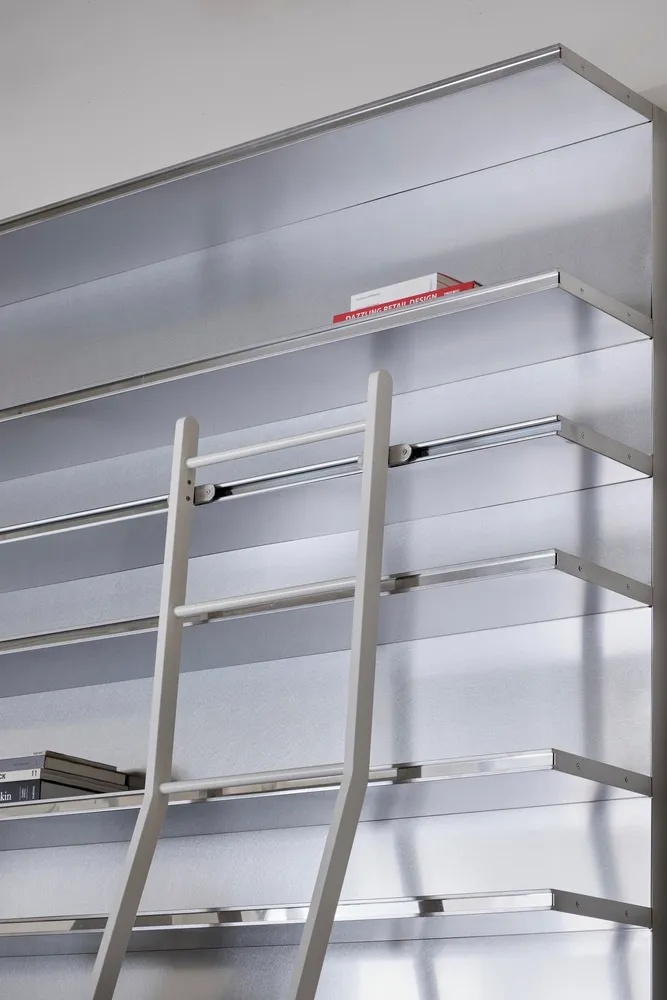 工業風圖書館中的金屬書架系統,搭配一架梯子。