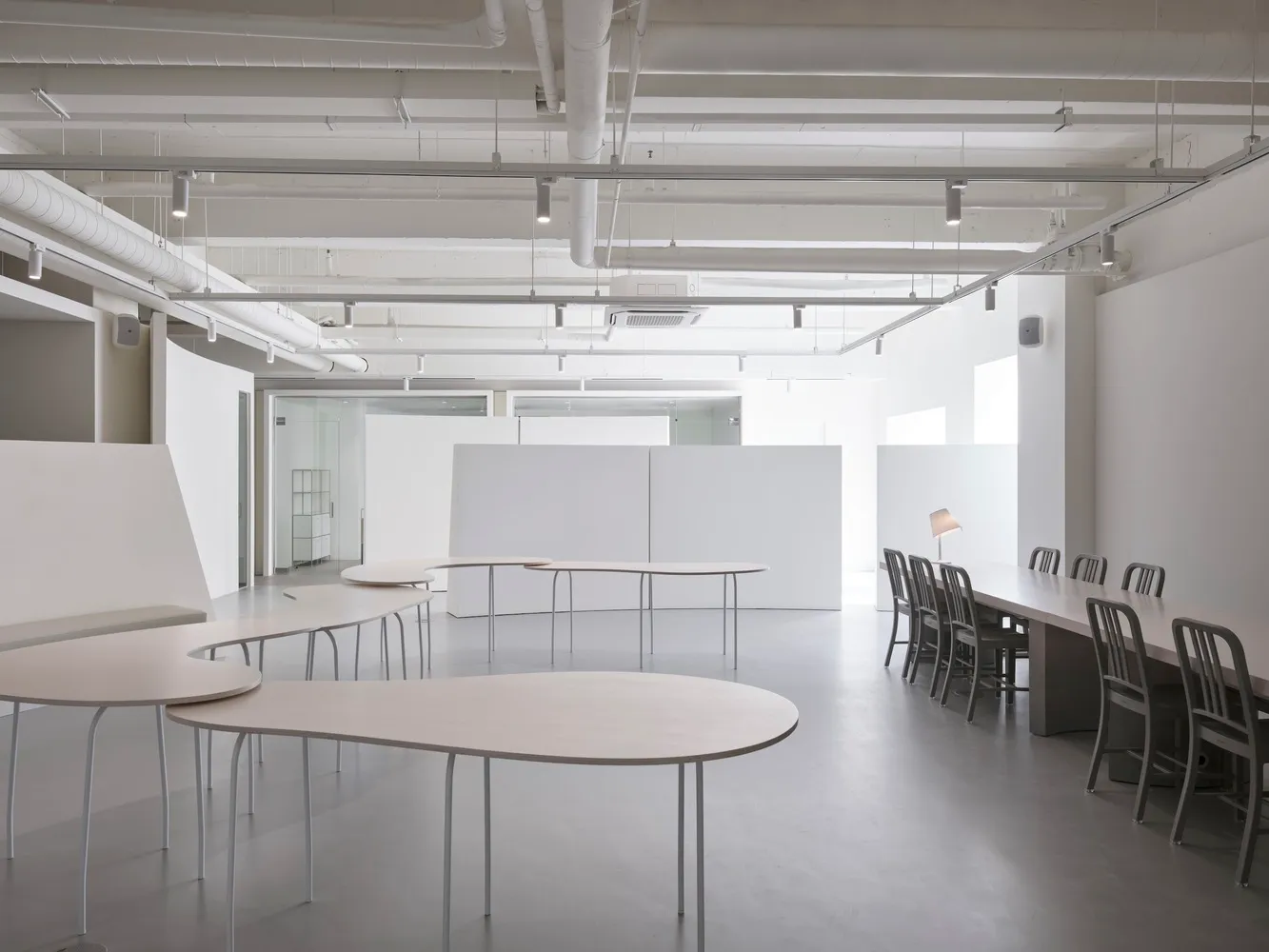 An empty, minimalist office space with white walls and furniture.