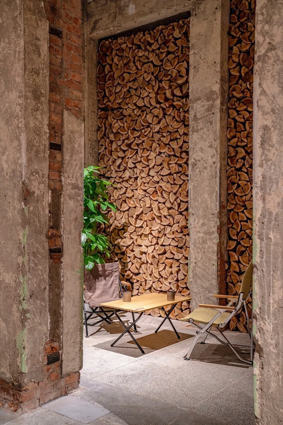 Industrial-style interior design featuring stacked firewood and seating area.