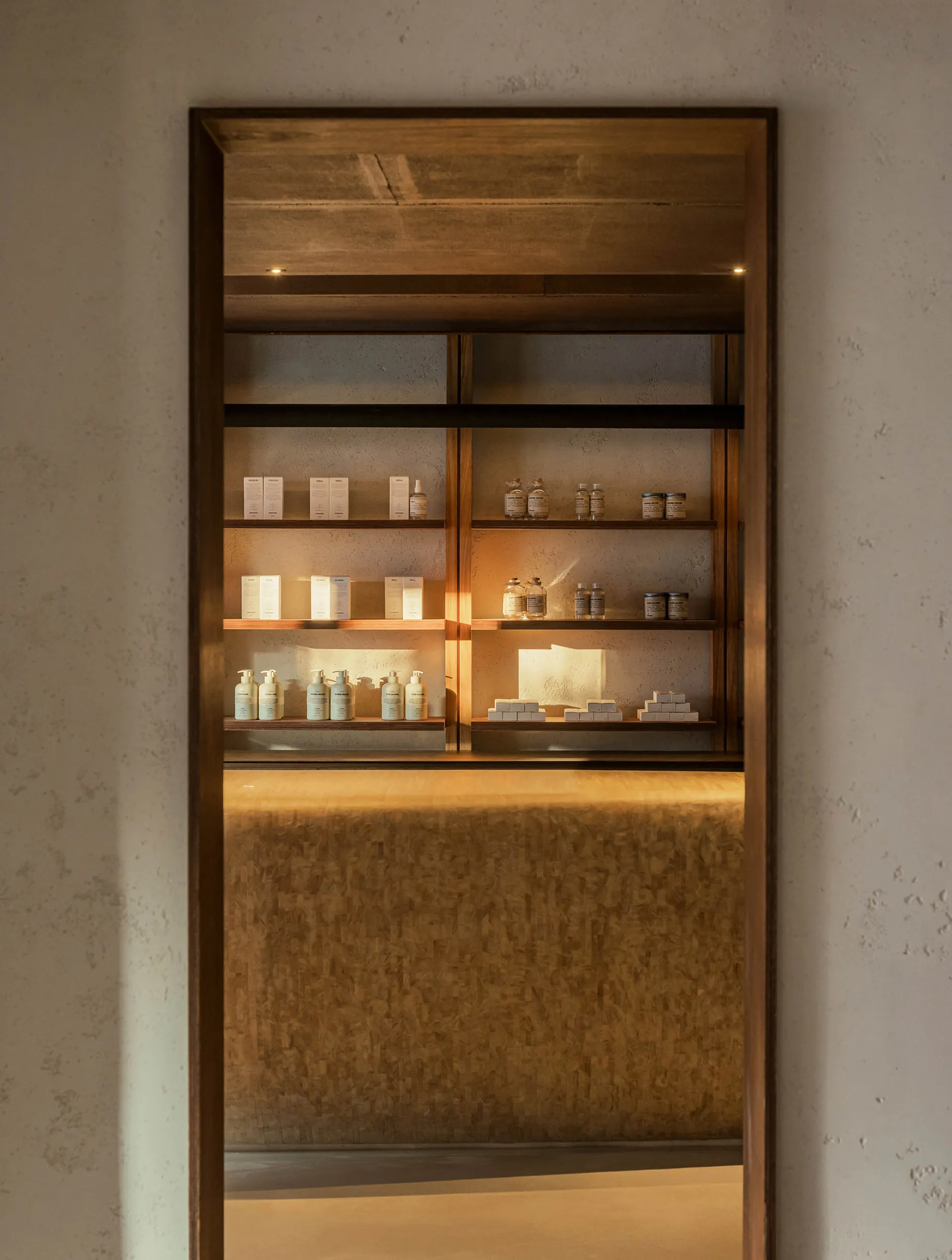 A modern retail storefront featuring wooden shelves displaying beauty products.