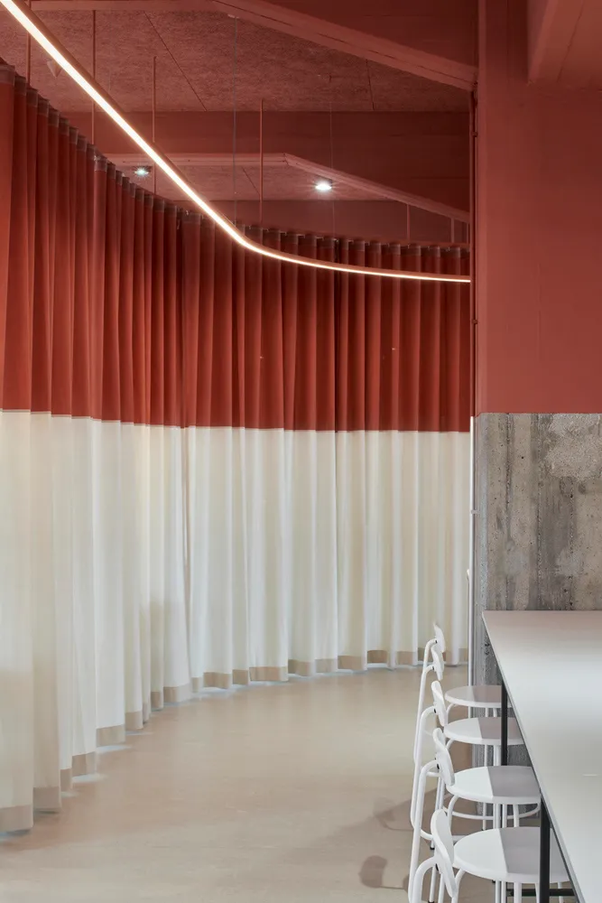 A modern cafe interior featuring textured red curtains.