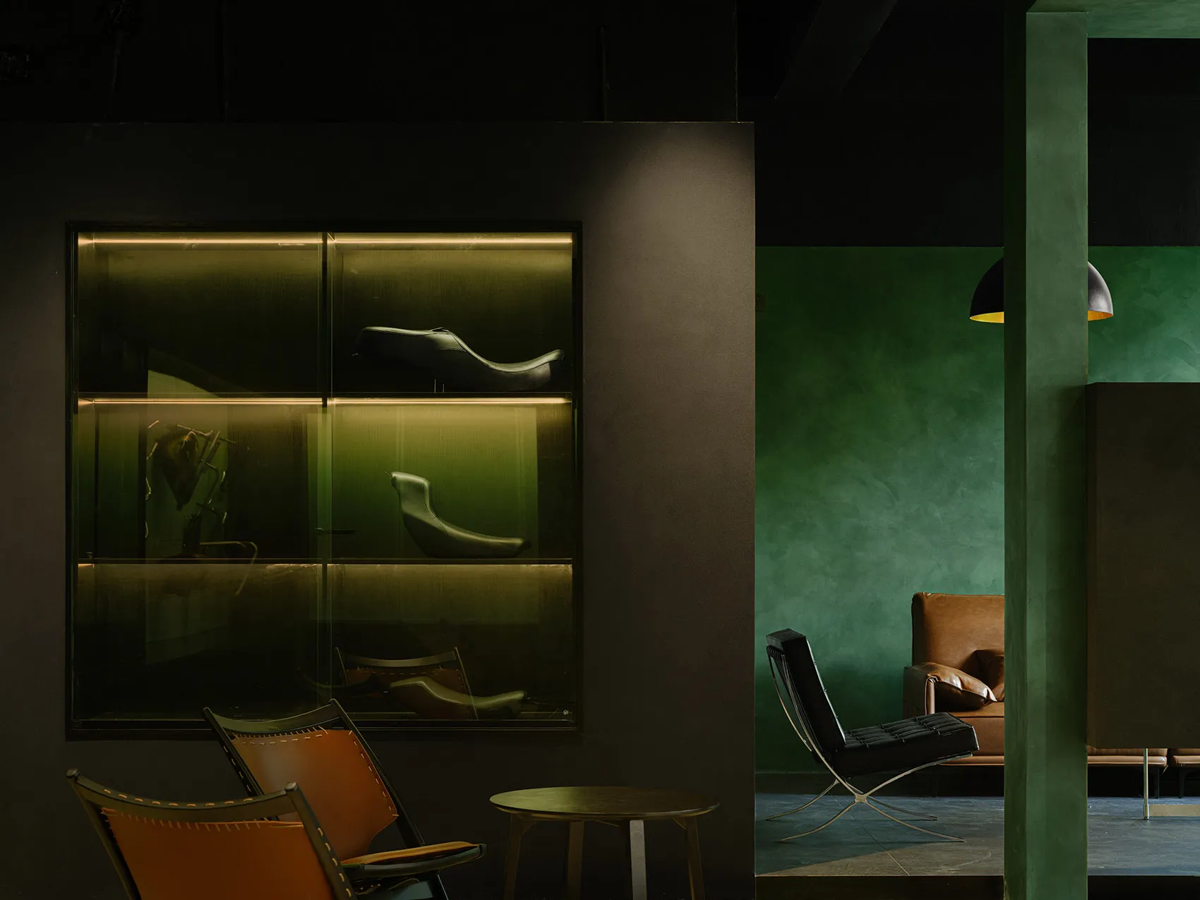 Modern lounge area featuring leather chairs, metal accents, and concrete walls.
