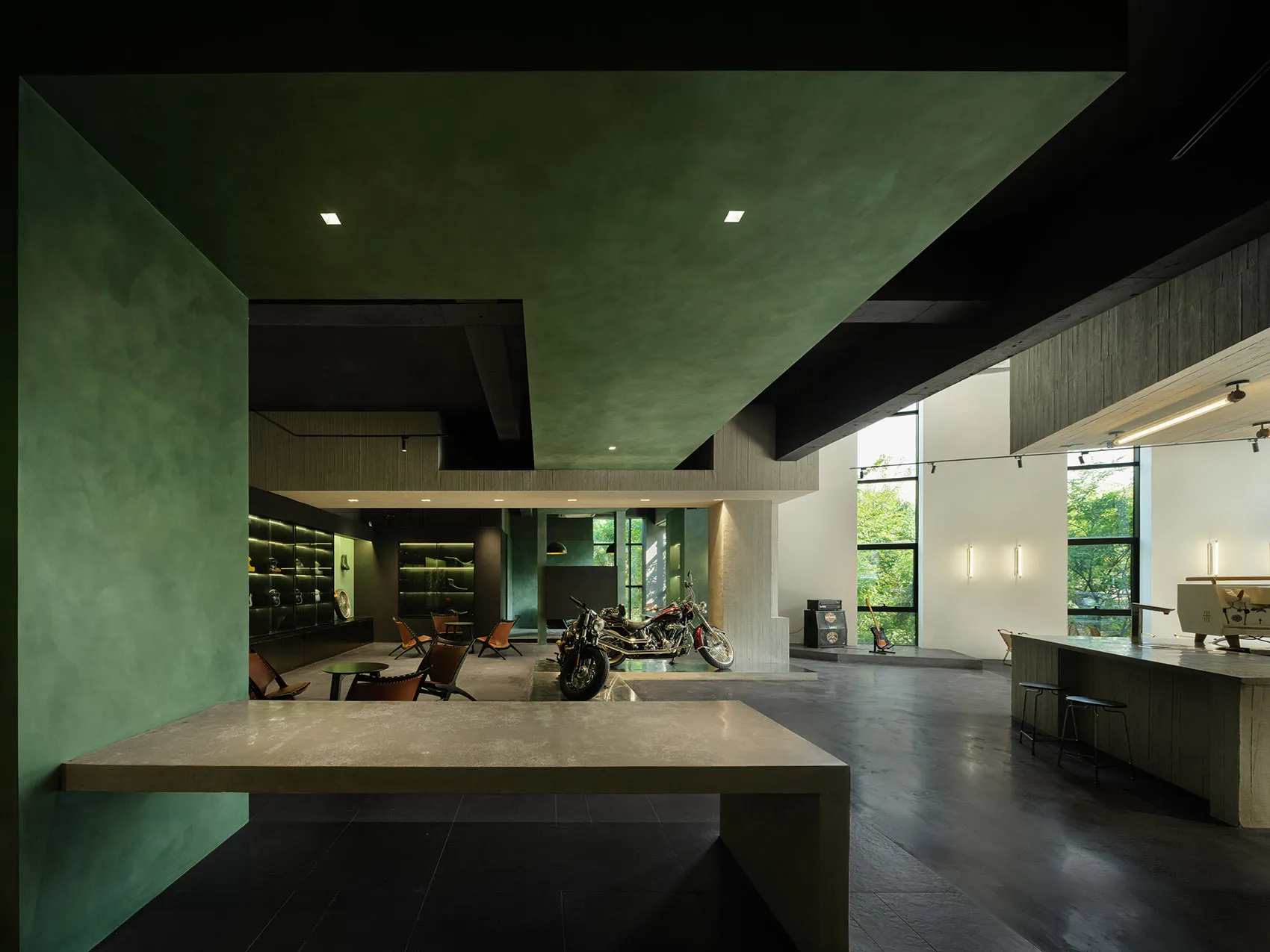 Indoor motorcycle showroom with modern design, concrete floors, and industrial-style furniture.