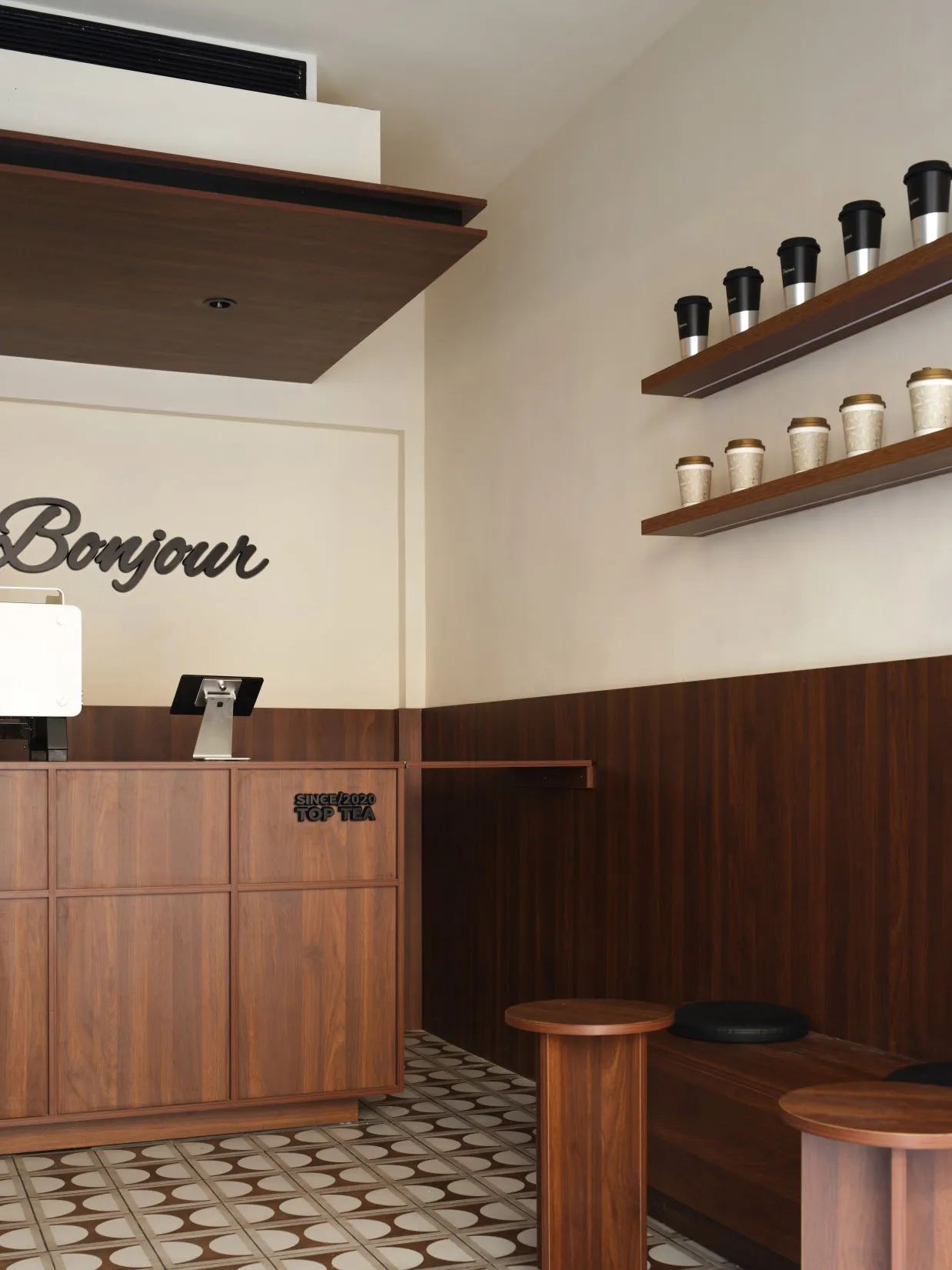 A modern cafe interior featuring wooden furniture and shelves.