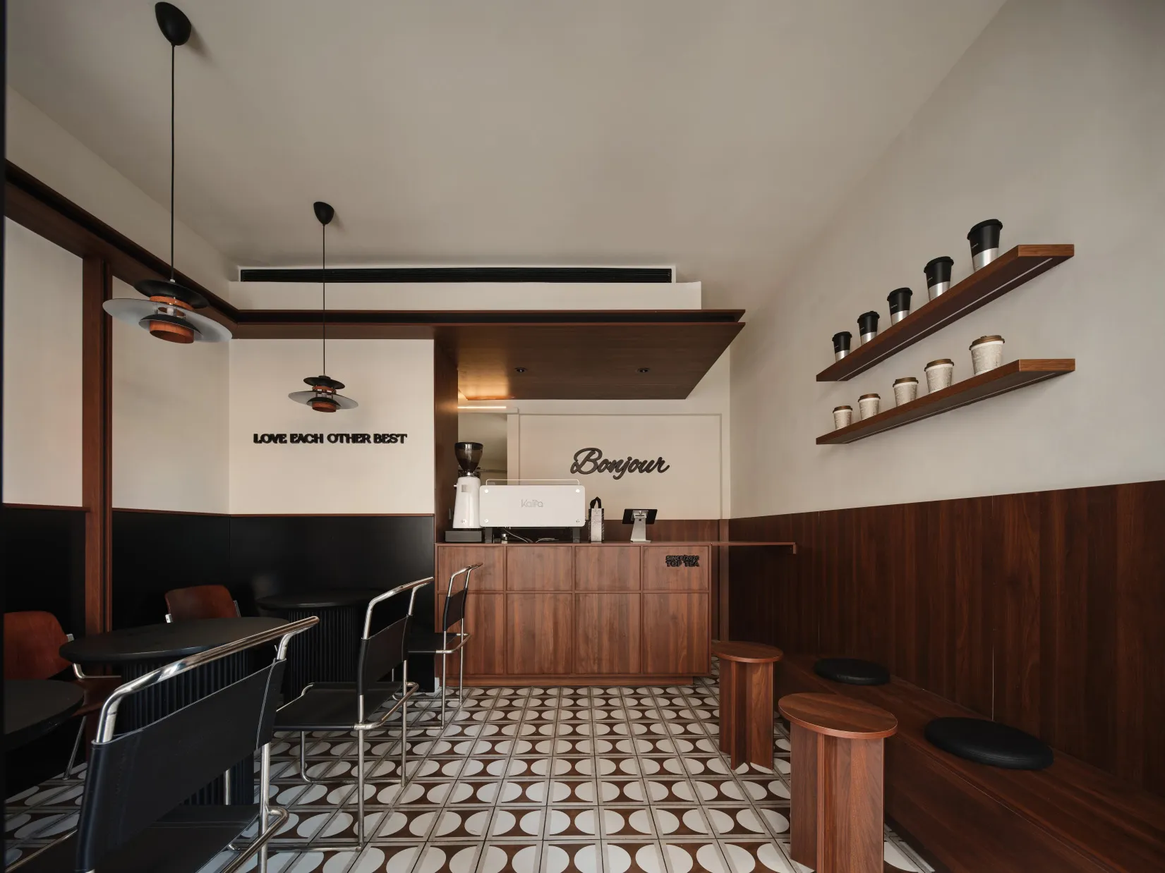A modern coffee shop interior featuring wooden and metal elements and ceramic tiles on the floor.