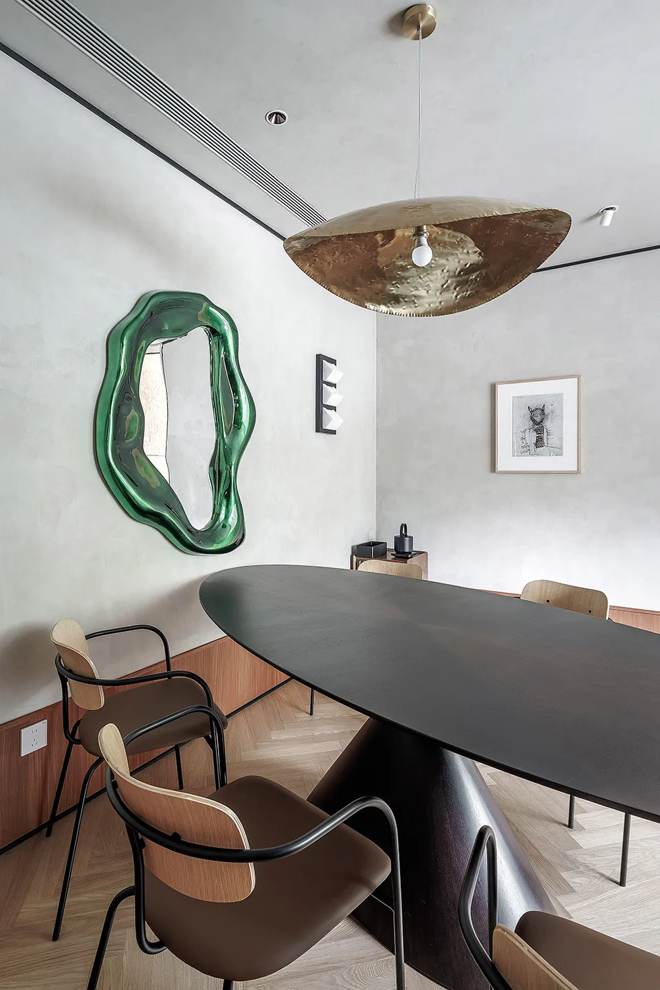 Modern interior design featuring a metallic dining table with wooden chairs and a contemporary art piece.