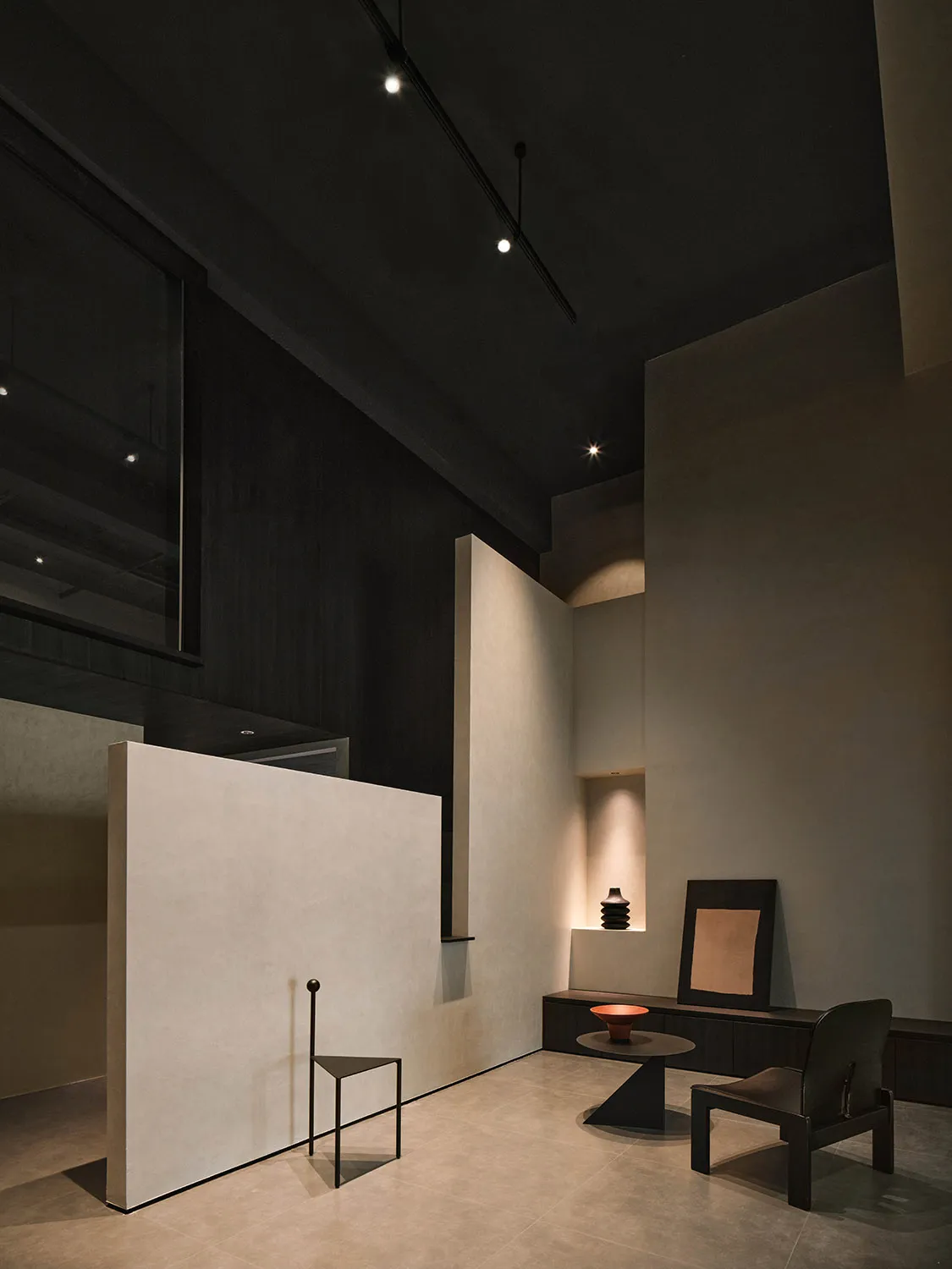 A minimalist concrete space featuring industrial-style furniture and modern design elements.