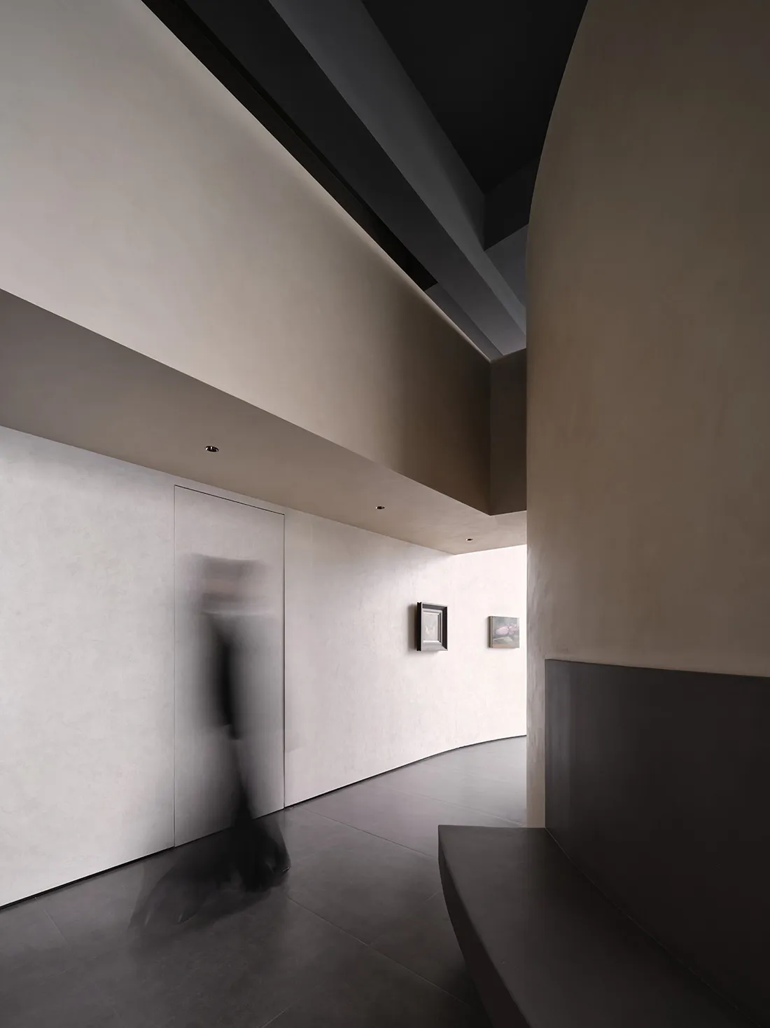 Modern minimalist living room decorated in neutral tones, featuring minimalist furniture and concrete and wood finishes.