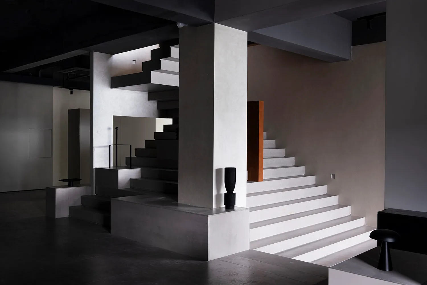 A minimalist interior design featuring concrete elements and industrial lighting.