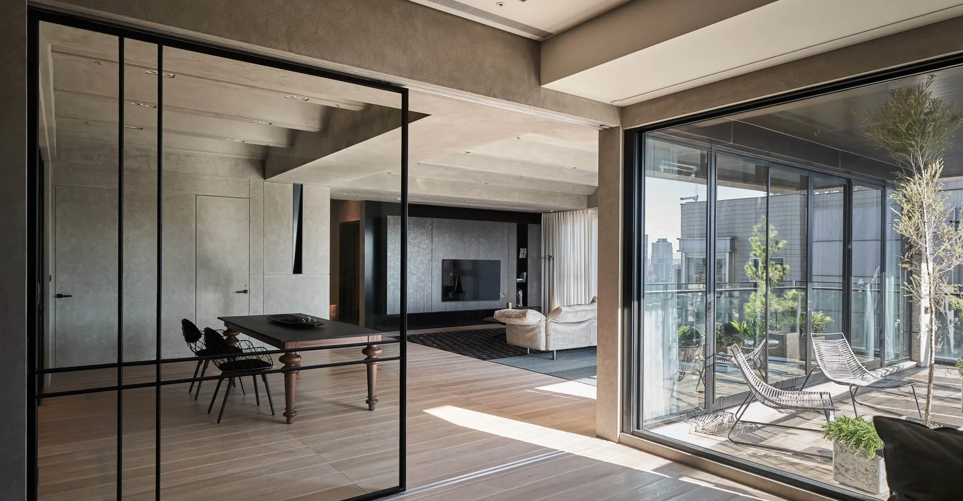Contemporary residential interior featuring hardwood flooring and floor-to-ceiling windows.