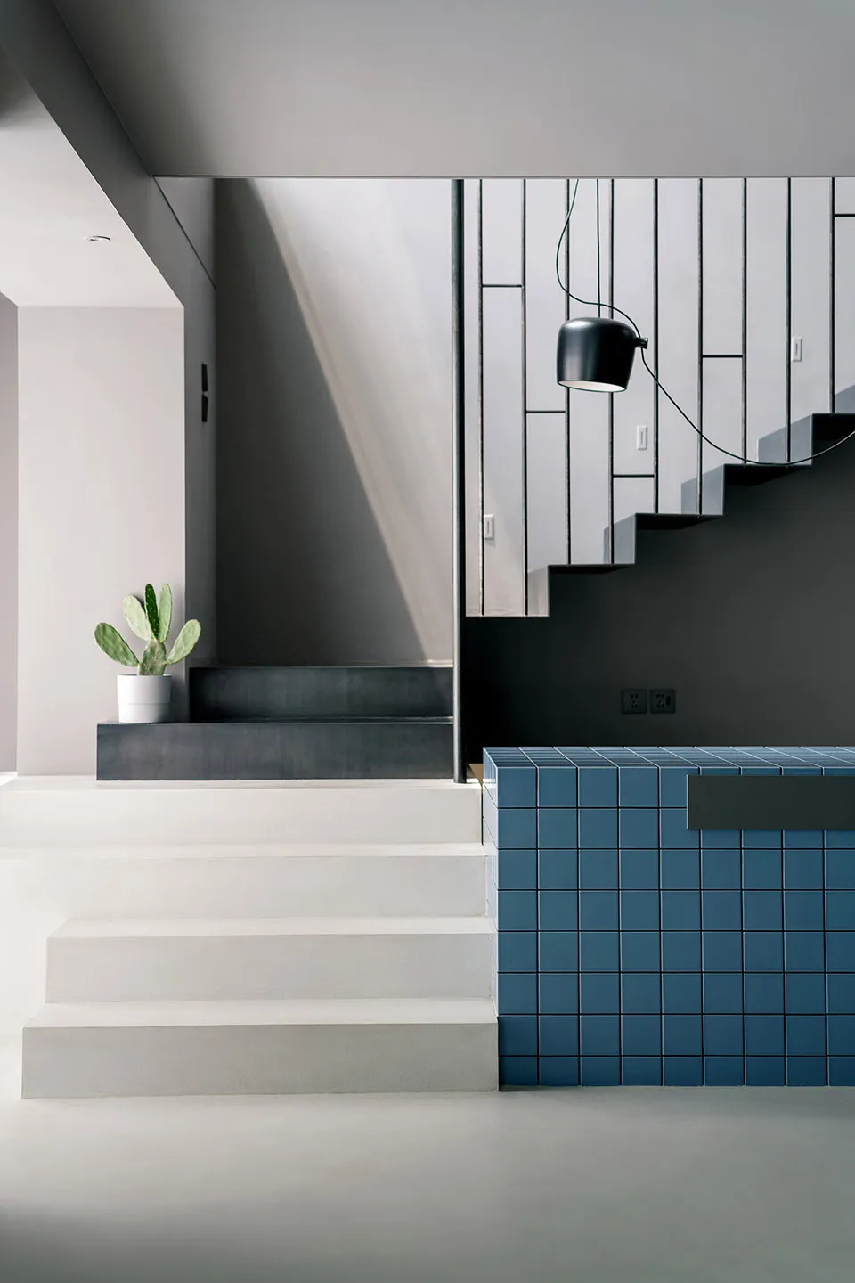 A modern interior space with concrete stairs and blue tiles.